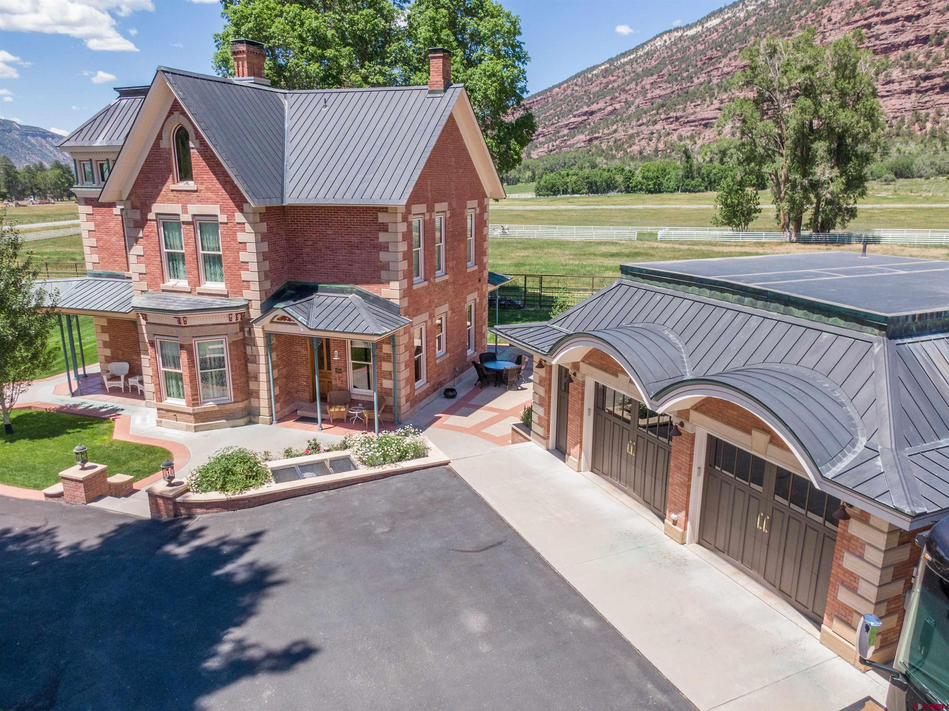 This Gorgeous Victorian Home is located in the beautiful valley just north of Ouray.  Surrounded by the majestic San Juan Mountains, this historic gem is listed on the National Historic Registry. Construction began in 1886 and was completed in 1888 by George Andrew Jackson, who is credited with discovering the first commercial gold deposits in Colorado and was the nephew of Kit Carson. The property underwent many changes over the years, eventually falling into disrepair and sitting vacant for some time. In 2000, a local judge and builder purchased the home and began an incredible 10-year restoration project. Updates included all-new plumbing and electrical systems, foam-insulated interior walls, a copper roof, new subfloors, central heating and cooling, and new doors and windows.  The next owners, who purchased the home in 2011, completed the restoration by 2013. The level of care and craftsmanship throughout is truly something you must see to appreciate. Custom walnut millwork, crafted by a local artisan, adds elegance to the interior doors, windows, baseboards, and cabinetry. Much of the original gingerbread detailing still graces the exterior, along with original elements of the staircase that leads from the foyer to the second level. Marble and wood floors are featured throughout the home.  The kitchen features reproduction Heartland appliances—including two ovens, a broiler, warming drawer, refrigerator, and dishwasher—creating a charming vintage ambiance with modern functionality. The finished third-story attic offers an office space and two bonus rooms.  There are three beautifully restored bedrooms, including an elegant primary suite, and three full bathrooms. The lawn irrigation system is fed by a 100-gallons-per-minute water well. Priority water rights on the Hosner Brownyard Ditch feed the pond and over an acre of agricultural land. The house itself is supplied by Tri-County Water.  The three-car garage includes in-floor heating, a fourth full bathroom, and a parking pad with a 30-amp plug for your RV. The private, expansive patio features an outdoor kitchen—perfect for entertaining.  The home is ideally located near a gravel road, perfect for biking to Ouray or Ridgway, and it's only 30 minutes from world-class backcountry skiing on Red Mountain Pass.  Call today for a showing!