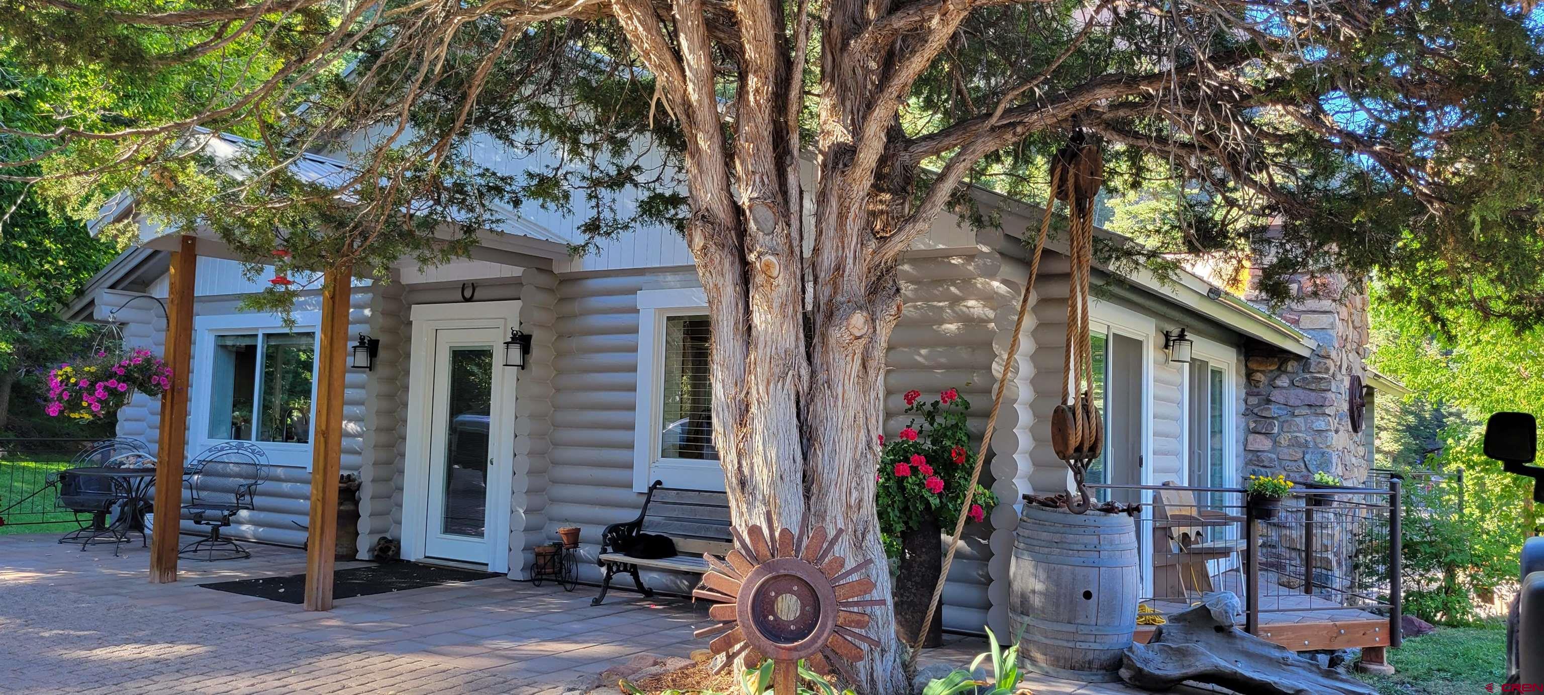 Nestled in the heart of Ouray on a large private lot with stunning views, this modern, warm, and cozy setting invites you to unwind and feel at home.  The open floor plan seamlessly integrates indoor and outdoor living, allowing natural light to flood the space, highlighting the rich textures and contemporary design.   Imagine sipping your morning coffee on the balcony, gazing out at breathtaking views or enjoying a quiet evening of serenity.   The fully equipped kitchen, adorned with sleek appliances and ample storage, is a culinary enthusiast's dream. A bonus 2nd kitchen on the lower level allows for an additional living quarter. Generous sized bedrooms suited for king sized furniture. A portion of the home is warmed by in floor radiant heated tile floors.  Detached oversized 2 car garage currently a wood shop with 220-amp service and a bear proof chicken coop or storage as needed. Additional log storage building and a partially fenced yard with a gate entranced drive.  Truly an inviting home.