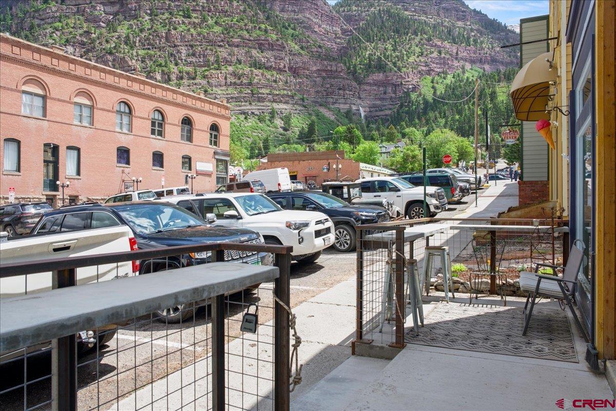 Fantastic commercial mixed-use/residential building located in the heart of downtown Ouray—known as the “Switzerland of America!” This property is an ideal live/work opportunity and offers a total of four units. The spacious upper-level apartment features two bedrooms and two bathrooms, an open kitchen/living area with large windows and stunning views, a generous laundry/utility room, a walk-in closet in the primary bedroom, and a lovely private deck. The main level includes two additional one-bedroom, one-bath apartments, as well as a commercial space currently operating as a charming hair salon. The property is zoned Commercial, allowing short-term rentals without an STR permit, meaning the units are not subject to STR taxes or permit caps. The front deck provides impressive views of Cascade Falls and the surrounding mountains. Please note: No FF&E is included in the sale. A 24-hour notice is required for all showings.