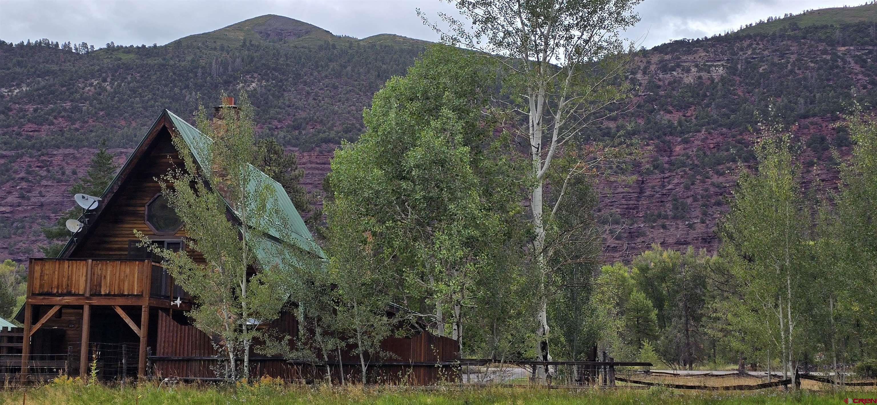 Nice views from this classic colorado mountain cabin on 2.57 irrigated acres in the sunny Idlewild subdivision between Ouray and Ridgway. 1 hour to Telluride ski area. The private porch and balcony off the primary bedroom, which boasts a separate shower and jetted tub, overlooks the pastoral valley. Beautiful kitchen with separate dining area and direct access to deck dining. Studio apartment in the garage building could be an office, craft room, or workout/yoga space. County regulations also allow for home business. 2.57 acres has plenty of room for toys, animals, or out buildings. This is a true slice of Colorado. Seller has an assumable loan at 2.87%!