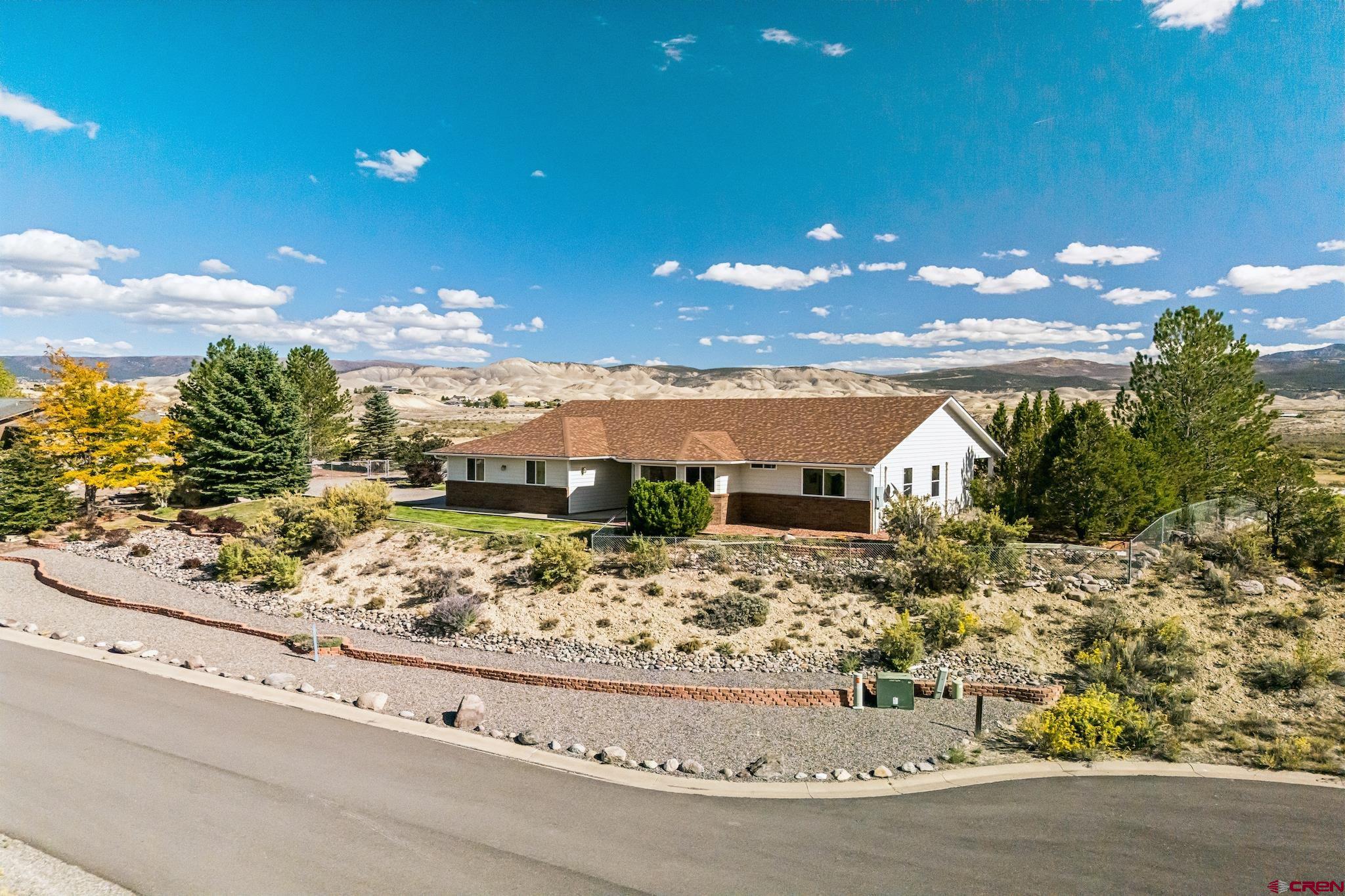 Welcome home to the quintessential beauty of western Colorado. Perched on a hill overlooking a valley on 1.35 private acres, this home offers unobstructed, panoramic views of the incredible San Juan Mountain Range. Wake up to breathtaking sunrises, unwind to glowing sunsets, and enjoy the peace and quiet of a property surrounded by nature. This one-owner home has been meticulously cared for inside and out, reflecting true pride of ownership. Recent updates include a brand-new roof in 2025, brand-new boiler in December 2025, heated gutters, and 4 mini splits throughout the home ensuring years of worry-free, comfortable living. Every detail of the property has been thoughtfully maintained, creating a move-in-ready home that is waiting for you to make it your own. Inside, you’ll find light and bright living spaces, a gas fireplace, and a lovely bay window in the kitchen. Step outside to take in the expansive views from your covered back patio and experience the tranquility that only this setting can offer. The HOA owns the protected open space across the street from the home as well as behind the home ensuring that no one will ever be able to build in front of you and take away the majestic scenery! Located just minutes from Montrose amenities, yet tucked away in a serene setting, this property blends convenience with the quiet charm of country living. All furniture, (with the exception of the Rolltop Desk in the entry way) is negotiable for sale.