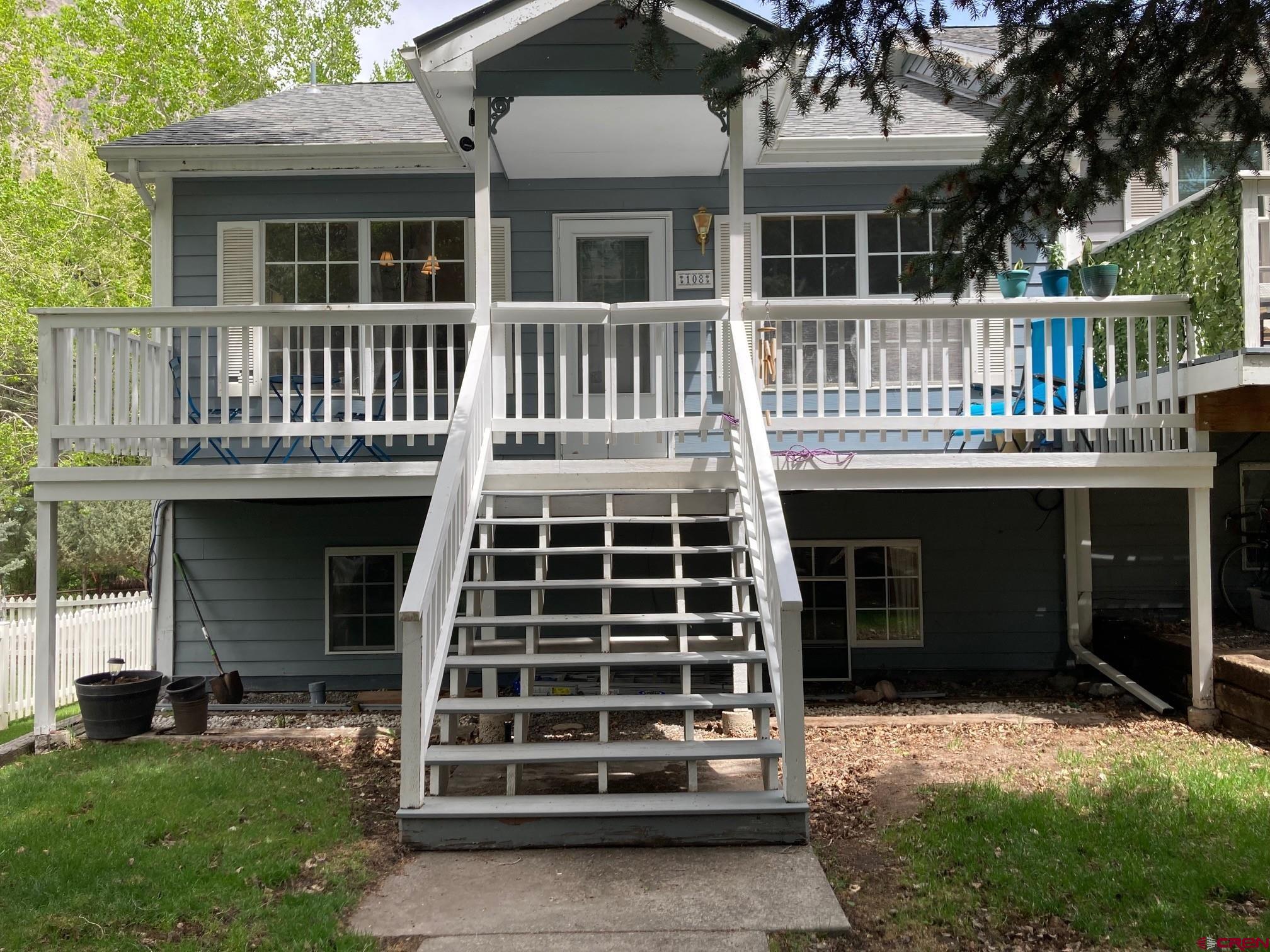 Experience the charm of Ouray living at 108 Spruce Street, a beautifully tucked away townhome just off Main Street, offering privacy, walkability, and mountain views. This 3 bedroom, 2 bath residence is ideal for full time living, a lock and leave retreat, or a smart investment opportunity. Just 1.5 blocks from downtown, it offers easy financing and the independence of ownership without condo restrictions, along with low HOA dues that cover yard and landscaping maintenance. The upper level features a bright, open living area with a spacious living room, dining space, and kitchen, along with the primary suite, full bath, laundry, and a large walk in closet. Step out onto the newly rebuilt Trex deck and take in views of the Rock of Ages and Amphitheatre peaks. The lower level includes two bedrooms, a full bath, and a convenient half kitchen with a sink, counter, and microwave area. With its own entrance, this level works well for guests or a private lock off setup. A garage and back entry provide easy access and storage. Versatile, low maintenance, and ideally located, this property offers strong potential for both comfortable living and long term rental income in the heart of Ouray.