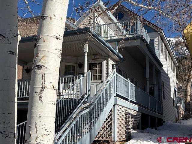 Discover a rare opportunity to create a custom mountain retreat in the very heart of Ouray, Colorado, often called the “Little San Francisco of the San Juans.” Located on the uphill side of 4th Street, just one block from the Ski Hill, this quiet and scenic property sits among some of Ouray’s most sought-after historic Victorian homes, offering a setting that perfectly blends mountain charm, walkability, and breathtaking alpine scenery.  Rooted in Ouray’s mining-era history, this unique home was thoughtfully created by blending a historic cabin with an ideal in-town building site. The result is a flexible mountain residence with duplex potential, featuring intelligently aligned entrances and stairways that allow for private, separate living spaces. Since its creation, the property has been a highly successful year-round rental, and the zoning allows long-term rentals of 30 days or more, addressing one of Ouray’s most in-demand housing needs.  Accessed via a south-side stairway, the home immediately showcases smart engineering for alpine conditions. Welded metal stairs and railings allow snow and ice to pass through, reducing winter maintenance and enhancing safety. At the top, a welcoming west-facing porch overlooks town with commanding views toward Twin Peaks and the Rock of Ages, setting the tone for the mountain lifestyle this home delivers.  From the porch, you may enter the main living level or continue to a secondary entrance—ideal for a private duplex unit or flexible multi-use living.  The lower level features a spacious great room with soaring ceilings, abundant southern windows, a bay window framing eastern mountain views, and a large private bath. The rear portion connects seamlessly to the main-level kitchen, dining, and office spaces, along with a second full bath. A back door opens to a covered rear deck, while interior stairs lead down to the full garage and workshop/studio area below.  The upper level is truly show-stopping, offering open, light-filled living with a well-sized kitchen and dining area, bedroom space, and a flexible living room. Step outside to the signature southwest-facing patio, where sweeping mountain views define the experience. The east end of this level delivers unobstructed vistas of Ouray’s famous Amphitheater, the dramatic mountain bowl above town known for its unforgettable nightly alpenglow.  The full-length lot includes a walkway to a storage area and a covered parking pad accessed from the alley—an ideal location for a future garage or potential ADU, offering additional income or guest accommodations. Parking and storage are exceptional for in-town Ouray, with on-street parking, a concrete pad, a two-car garage tucked beneath the home, and a generous workshop or studio space.  The property has been thoughtfully leveled and landscaped with perennial plantings, stone walls, and exterior lighting, reflecting the care and vision of its creators.  Due to a mid-winter leak, the upper levels have been cleared, with drywall and flooring removed. Most cabinets and fixtures are intact and ready for reinstallation, giving the next owner a rare chance to customize finishes and elevate the home to their own vision—whether modern mountain, historic restoration, or a blend of both.  Whether you’re seeking a primary residence, second or third mountain home, or a long-term rental investment near Ouray, Ridgway, Silverton, and Telluride, this property offers location, flexibility, views, and character that are increasingly rare in the San Juan Mountains.  This is your chance to own a piece of “Little San Francisco” in the Switzerland of America—where history, adventure, and alpine beauty meet.  Schedule your private showing today and imagine what’s possible.