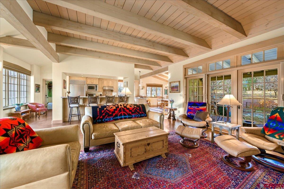 Every now and then a home comes along that wraps its arms around you and won’t let go. This is one of those homes. From the minute you walk in the door you know this is going to be something special. A wall of windows facing east leads you the warm and inviting great room made all the more special by its wood beam and decking ceiling, wood burning fireplace with cabinet surround and another window wall facing west with doors leading to the patio, bringing the outside in. Stained concrete floors throughout the main floor add a special feel that enhances the already incredible charm. There is not one step to deal with on this level. The kitchen opens to the great room allowing the cook to remain part of the gathering of family and friends. Granite counters, stainless appliances including a Sub-Zero refrigerator, alder cabinetry, a breakfast bar and a delightful window sitting at counter level make this such an enjoyable place to spend the countless hours we all spend in the kitchen each day. The formal dining room is adjacent to the kitchen and great room. Surrounded by windows once again, it has an element of charm seldom found in homes today. The master suite, complete with a wonderful window seat flanked by windows on the east side, is delightful as is the bath with its double vanity, granite counters, no-step tile shower, alder cabinets with lots of storage and tile floor. The den/office/studio features built-in cabinetry and access to the rear patio and courtyard. Upstairs are two bedrooms, each with its own bath for family and friends. Both baths have tile counters and floors, one has a shower and the other a tub-shower. Grandchildren will enjoy playing in the unique attic space and the sitting area between the bedrooms is a great place for guests to spend time with a good book! The laundry room is very large, includes a walk-in pantry, is a perfect mud room with direct access to the 2 ½ car garage. Plenty of room for the cars, the golf cart or other toys! It is Fall going on Winter so it is hard to appreciate the beautiful wildflowers in the rear courtyard. The patio easily becomes another family room and is a great spot for a game of cards, a family meal or just sitting with a glass of wine in the evening or that first cup of coffee in the morning.  The remarkable charm of this home cannot be emphasized enough. The wood treatments, windows, natural light, the ceiling heights that are not cavernous, the flooring, a premier builder (Curt Quadri), ease of living on the main floor with no steps, the courtyard and patio all combine to make this a very, very enchanted place. The owners also own the adjacent lot to the west which is shown in the photos delineating the property lines. If the concept of a family compound is on your radar, or you simply would like a buffer, know that the lot is available for purchase. Fairway Pines Estates is a short scenic drive from Ridgway to the top of Log Hill Mesa. The community offers many amenities not the least of which is the spectacular 18-hole Divide Ranch Golf Course and Club. The views from the various holes are breathtaking and never the same two days in a row. The clubhouse is magnificent overlooking a quiet pond and up to the San Juan and Cimarron Mountain ranges. Purchase of this home comes with a Founders Membership in the Club and requires a transfer fee of $3,000.  The ever popular town of Telluride is an hour away and offers world class skiing as well as a full calendar of festivals in the summer. All in all, this special home in this special community surrounded by spectacular scenery and activities any time of year offers an opportunity to escape the hustle and bustle of other areas and return to a simpler lifestyle that is hard to find in today’s world.