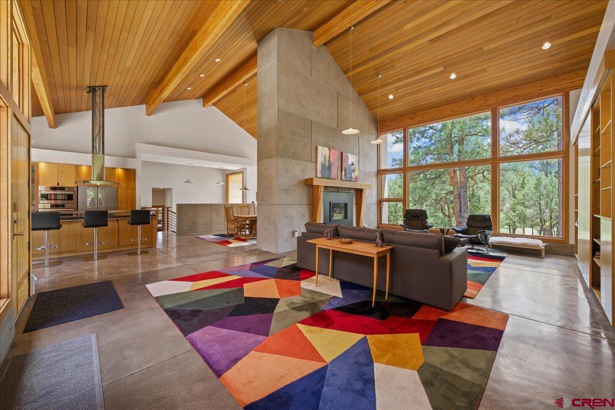 UNMATCHED VALUE!  Opportunity knocks at the Divide Ranch & Club. This architectural masterpiece boasts 3,453 square feet of high-end, custom living space in this turn-key mountain contemporary home located on the golf course. Set on a private, wooded .92-acre lot with easy access to Tee Box No. 2, the home captures bucolic golf course views, visiting wildlife, and mountain peaks through pine trees from floor-to-ceiling picture windows and a spacious back deck nestled in the woods. The recently re-stained all-cedar exterior and welcoming entry lead to a low-maintenance interior with stained concrete floors and walls, a split floor plan, and dramatic 21-foot vaulted tongue-and-groove cedar ceilings. The grand living room features a gas log fireplace, built-ins, and seamless flow to a chef’s kitchen with Caesarstone countertops, top-line appliances, pantry, stainless steel breakfast bar, and generous dining area. The primary suite includes deck access and a loft office reached by a metal spiral staircase. A media room with theater seating, second bedroom, bath, and fitness/flex room complete the home. The oversized detached two-car garage provides plenty of room for vehicles and all the essential Colorado “toys” (bikes, kayaks, etc.).  Surrounded by the San Juan Mountains, Divide Ranch & Club offers challenging golf, spectacular scenery, snow shoeing and cross country skiing in the winter, and convenient access to Ridgway, Ouray, Telluride, and Montrose. The sellers have aggressively repositioned the price to $1,299,900, leaving massive financial "meat on the bone" for the next owner. This price point represents an undeniable bargain for this scale of luxury.