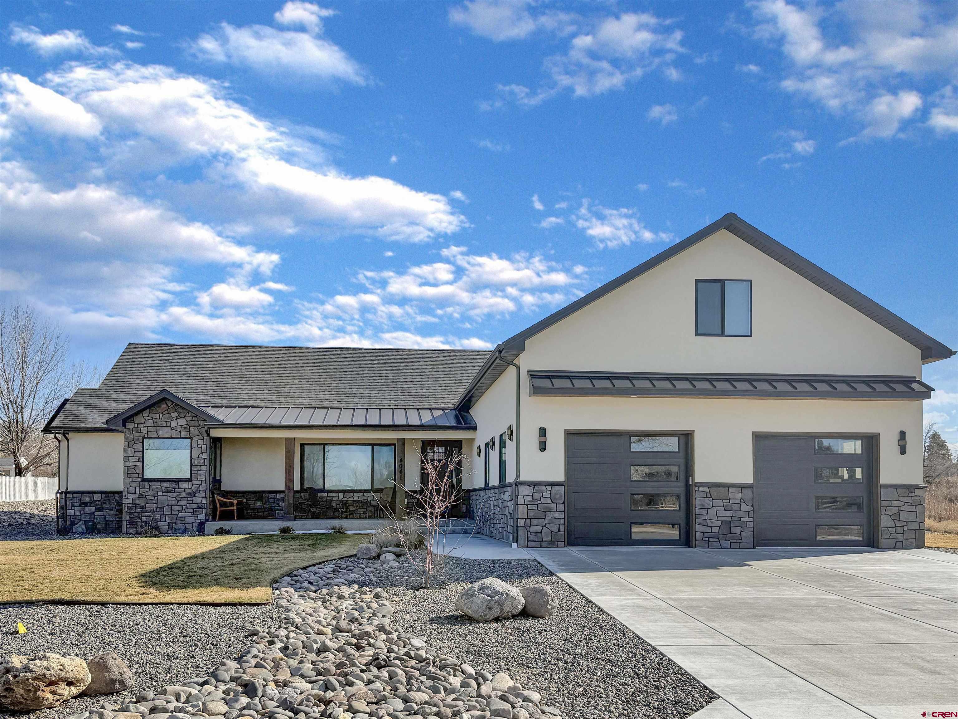 Nestled on a sprawling half-acre lot within The Brook defined by its rolling hills, mature trees, and serene community ponds, this 2023 custom built ranch style residence features a thoughtful split floor plan on the main level for effortless everyday living, complemented by an upper-level bonus room, a fourth bedroom, and ¾ bath. The upstairs is ideal as a guest suite or recreation retreat. Exceptional craftsmanship is evident throughout, especially in the stunning great room where the chef’s kitchen with high-end appliances and an oversized island create a true centerpiece for entertaining. The living room features a striking gas fireplace adding warmth to the entire great room. Natural light floods the home from both directions—morning sun illuminates the dining room in the front of the home overlooking community open space and a peaceful pond with no homes directly across the street, while southern windows brighten the living area and frame views of the private back patio and yard. The luxurious primary suite offers direct patio access and a spa-inspired bath with a freestanding tub, a beautifully tiled separate shower, and a generous walk-in closet. Guest accommodations are privately positioned on the opposite side of the home with access to an elegant full bath. A large laundry room with an adjoining office/craft/flex space adds everyday convenience, while custom built-in cabinetry near the garage entry provides stylish, practical storage. There are multiple areas for storage, including a large pantry with power outlets and understairs storage, throughout the home to keep belongings nice and tidy.  The generously oversized two-car garage offers abundant room for vehicles, gear, and equipment. Easily maintain your half acre with irrigation water via the HOA with dues of only $430/year. Enjoy the quiet elegance of The Brook while remaining just minutes from the Montrose Recreation Center, premier shopping, and popular dining.  Your perfectly positioned, too, for enjoying walking paths through The Brook located right outside your door.  With 245 days of sunshine and the signature blue Colorado sky above, embrace an elevated Western Slope lifestyle and make this exceptional residence your next home.