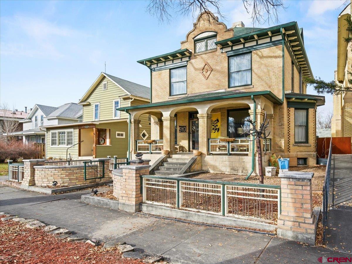 Come experience one of Montrose’s most iconic historic homes, ideally situated in the heart of the Montrose Town Core where walkability, convenience, and classic Western Colorado charm come together. Built in 1900, this beautifully restored turn-of-the-century estate reflects the architectural elegance that helped shape Montrose, while offering modern comforts and a flexible lifestyle that today’s buyers value. Its central location provides easy access to shops, dining, medical facilities, and air service, making it an ideal home base for both full-time living and investment.  Set on a fully developed 6,250 square foot lot, the property includes two distinct residences: a stately 3,300 square foot manor and a thoughtfully converted carriage house ADU. The guest cottage provides a strong and proven income stream, currently functioning as a highly desirable rental, while also offering versatility as a long-term rental, guest home, office, or studio. This dual-home configuration creates an exceptional opportunity to offset ownership costs while preserving privacy and flexibility.  The main residence spans three expansive levels and showcases classic architectural details throughout, including soaring ceilings, oversized windows, original hardwood floors, and intricate wood trim. These historic elements are seamlessly blended with modern systems, fixtures, and appliances. Gracious living and dining spaces flow from the elegant front porch entry, while the well-appointed kitchen serves as the heart of the home, opening to a beautifully landscaped backyard retreat.  Additional living space on the lower level offers separate access and further income or guest potential, complete with a fireplace and bath. The upper level features oversized bedrooms and a refined primary suite with a walk-in closet, soaking tub, and oversized tiled shower. Outdoors, stone pathways, mature landscaping, and a greenhouse complete this private oasis. This is a rare opportunity to own a landmark Montrose property that combines historic architecture, an income-producing ADU, and a premier in-town location.