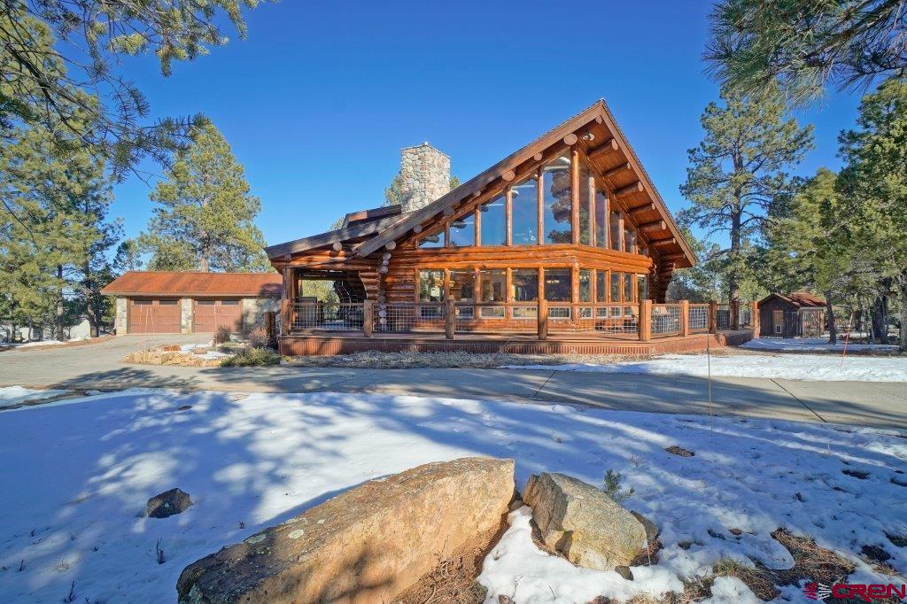 This exceptional Colorado log home set on .92 acres within the prestigious Divide Ranch & Club, captures breathtaking San Juan Mountain views and delivers refined modern mountain living in one of Ridgway’s most sought-after communities. Offering 3,822 sq ft with 4 bedrooms and two full baths + one ¾ bath, the home blends timeless log craftsmanship with a spacious, light-filled layout designed for both comfort and elevated entertaining perfect for hosting family and friends. Expansive living areas feature 26ft vaulted ceilings, wood burning fireplace, rich natural wood finishes, and large windows that frame the surrounding peaks. The kitchen anchors the home with new appliances, generous granite countertops, quality finishes, and seamless flow to the dining and living areas. The main level of the home includes the primary suite which serves as a private retreat with serene forest views and an ensuite bath and large walk-in closet. The main level also includes laundry and pantry plus 2 additional bedrooms with a shared full bath. The upstairs loft area includes a very large space for family entertaining (home theater and family gaming area). It also includes a large bedroom suite and private bath. The entire home and 2 ½ car garage include heated floors. For your comfort, the mini split air conditioning system (located in the living room and upstairs loft area) were installed just a few years ago.  Multiple outdoor living spaces (including a large renovated trex deck) invite year-round enjoyment of the scenery, fresh alpine air, and peaceful setting, with convenient access to the Divide Ranch & Club golf course and clubhouse. This property also includes a large fenced area perfect for children and dogs. You'll enjoy easy access to Ridgway, Ouray, Telluride Ski Area and Montrose (including airport, recreation facility and performing arts center). Come see what a luxury mountain lifestyle paired with world-class recreation can be.