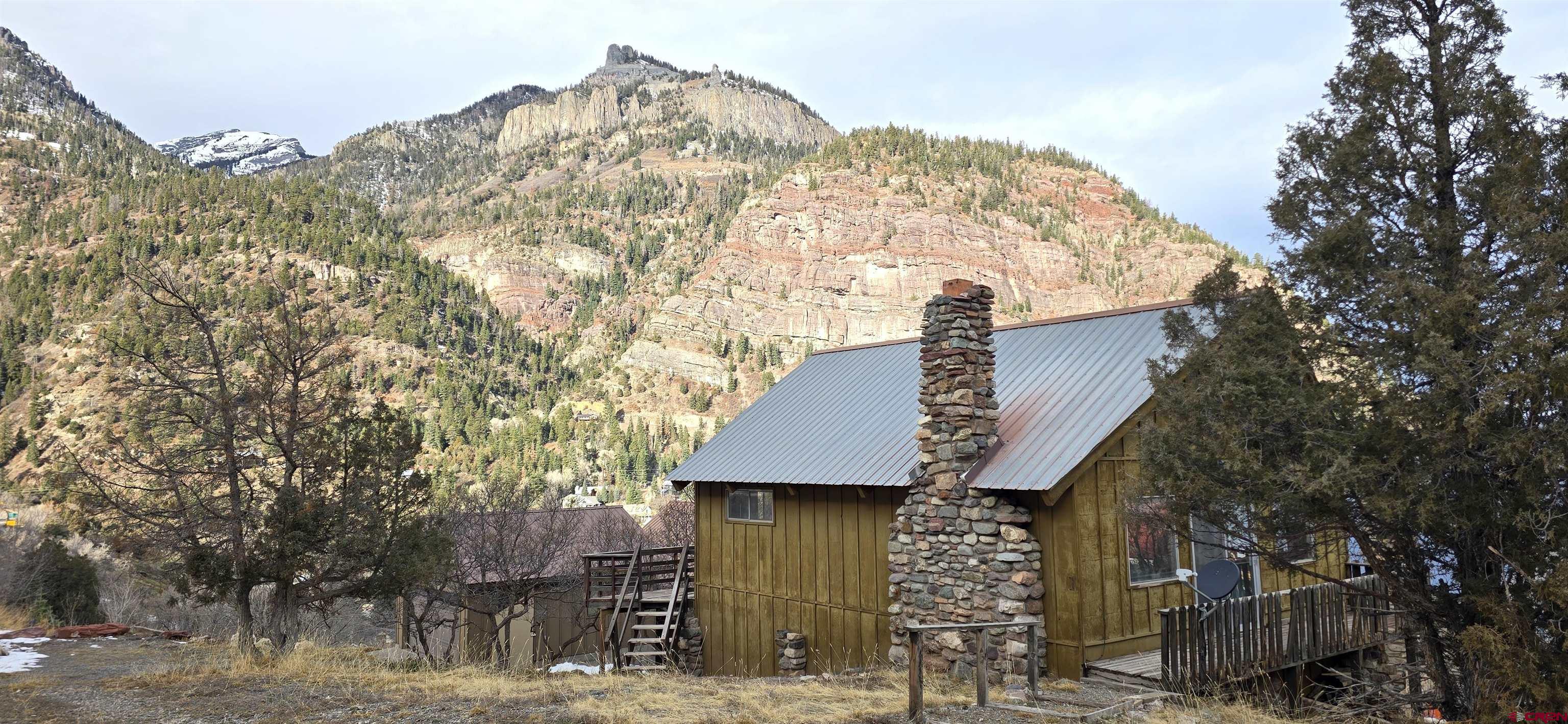 Location, location, location!!! This is the best location in Ouray with the most amount of sun, stunning 360 degree views, and a feeling of space being a corner lot. Though it is a short walk to town (less than 5 minutes), it’s a bit hidden from the tourist and almost feels like a cabin in the woods starring right into “The Amphitheater," one of the most spectacular grand views in Ouray!   The property has been inspected by the Ouray building official, San Miguel Power Association has upgraded the service box, the sewer line was inspected with a camera, the water line was drained. The house was built in the 80’ as a summer retreat with the foundation built on solid limestone bedrock, so structurally sound, however basically needs to be gutted, re-insulated and remodeled to your heart's desire.   The open floor plan, high ceilings and loft make this 720 sq ft home feel much bigger and could be remodeled into a 2 bed, 1 bath home. This highly sought after location has some of the most expensive homes in Ouray currently being built, but this home's unobstructed views will never be lost. This is truly a diamond in the rough…