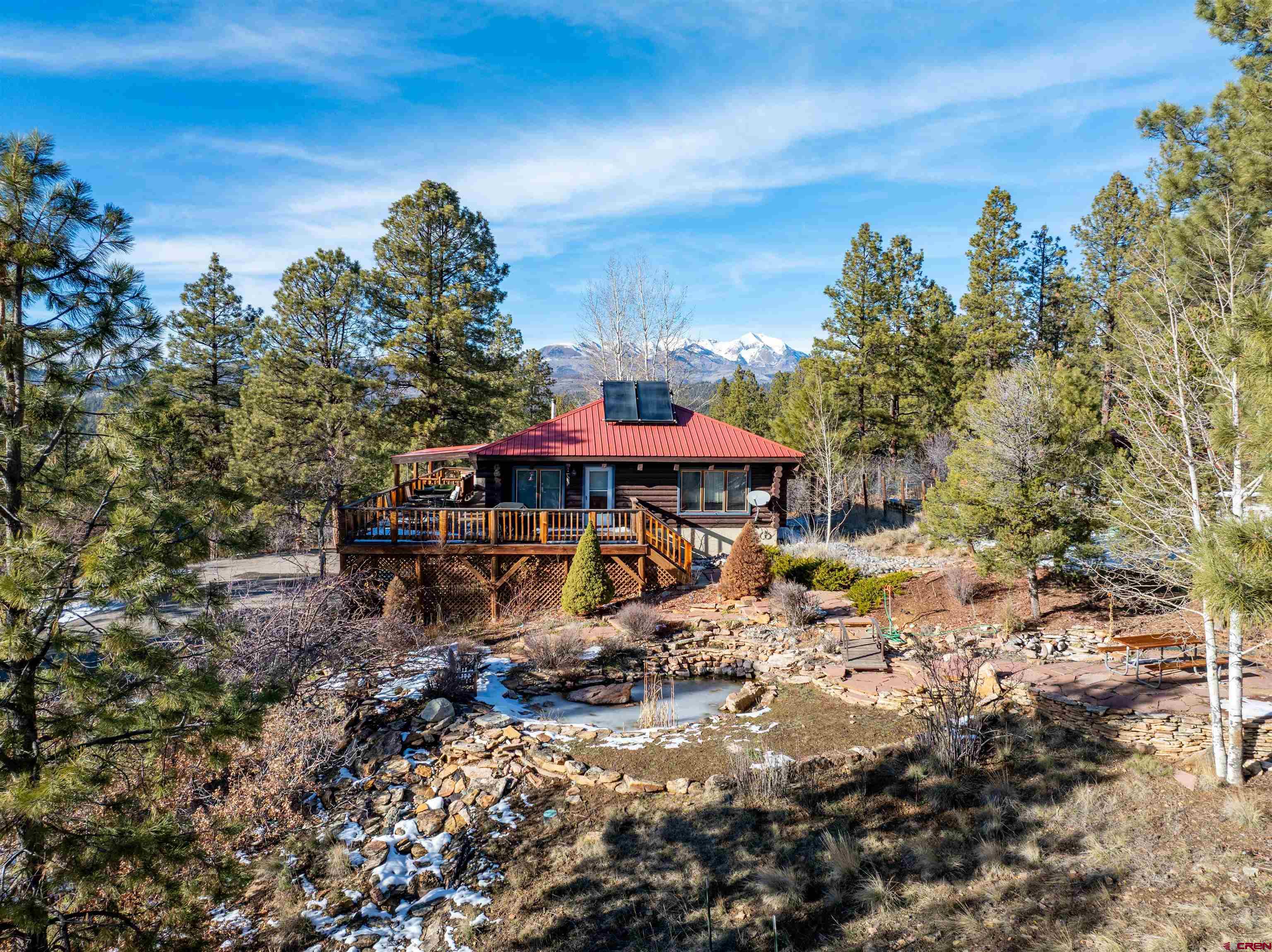 MAIN HOME WITH ADU! Tucked away off the beaten path yet just minutes from town, this rare Colorado mountain retreat offers privacy, flexibility, and exceptional income potential on 10+ private acres with sweeping La Plata Mountain views. The 4-bedroom, 3-bath custom log home has been thoughtfully maintained and designed for full-time living, a luxury second home, or a high-performing short-term rental. In addition is a detached ADU with parking, more info below. Inside the main house is an open and functional layout featuring a dining area that comfortably seats eight plus additional pub-style seating, a well-appointed kitchen with granite countertops and newer stainless-steel appliances, hardwood floors throughout the second level, and updated bathrooms. Two upper-level primary suites each include full baths & mountain views. The lower level offers two additional bedrooms, a shared bathroom with tub, full-size laundry room, HVAC, and a private sauna seating up to six- perfect for post-adventure relaxation. Adding exceptional value is the detached accessory dwelling unit (ADU), offering two bedrooms, one bathroom, full kitchen, living room, and laundry. Ideal for guests, caretakers, multigenerational living, or additional rental income, the ADU provides rare versatility and privacy. Outdoor living is a standout feature, with a wraparound deck and hot tub overlooking the mountains, perfect for entertaining or quiet evenings under the stars. The property is surrounded by mature aspens, fruit trees, abundant wildlife, a tranquil fish pond, and a peaceful meditation garden, creating a true mountain sanctuary. Additional features include a one-car garage, covered parking, storage shed, ample additional parking, and easy year-round access. The exterior log construction has been professionally maintained with regular chinking and staining, reflecting true pride of ownership. Located approximately 8 miles from Historic Downtown Durango, 34 miles from Purgatory Ski Resort, and close to world-class hiking, biking, fishing, rafting, and skiing, this property offers the perfect balance of seclusion and convenience. With approximately $70k in gross rental income reported in 2025 and no HOA so this is a rare opportunity to own a mountain retreat, income-producing vacation rental, or private family compound in Southwest Colorado (without limitations on use or monthly dues). Opportunities like this are limited!