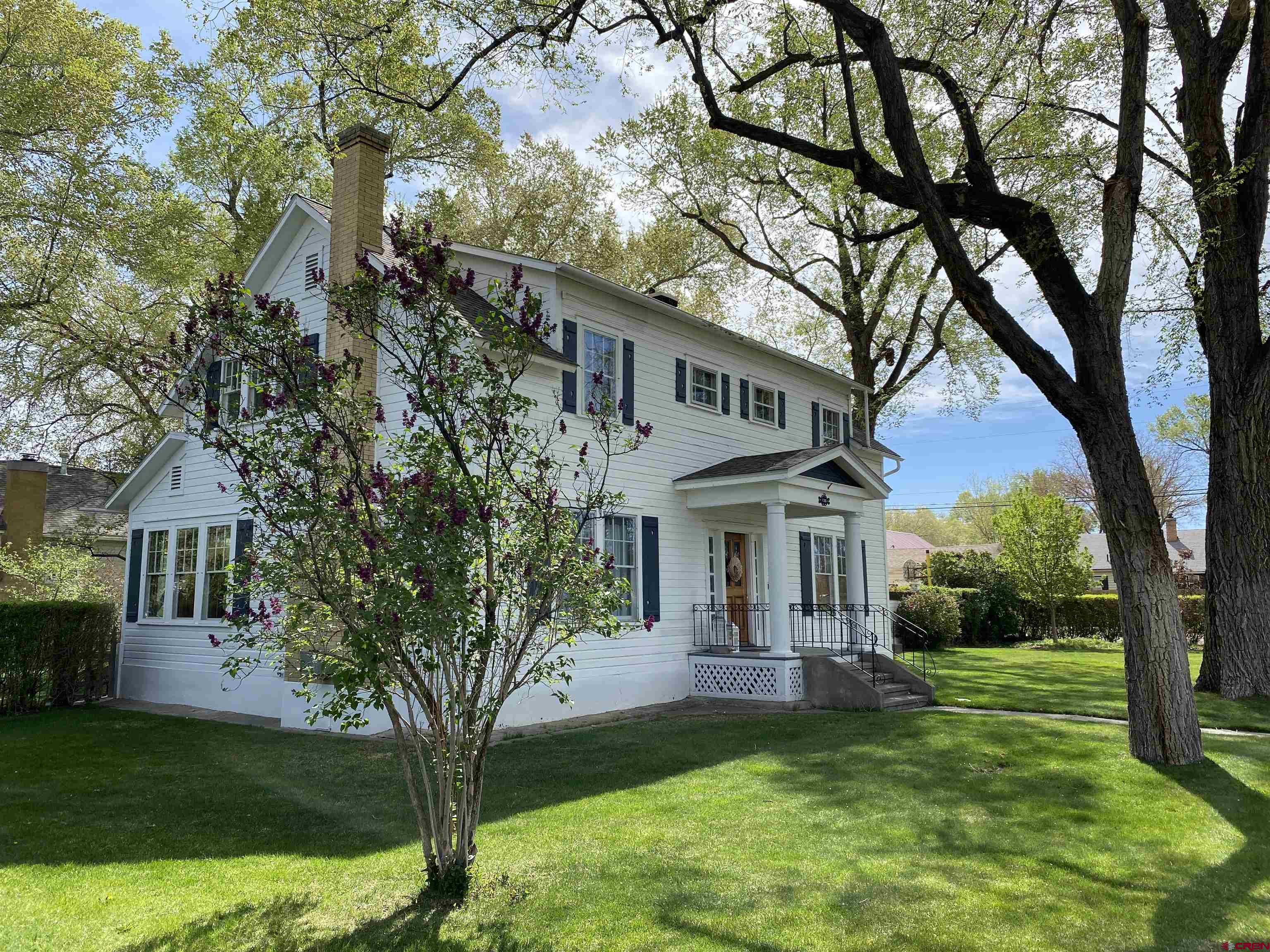 Stately, majestic, and rich in Montrose history, this beautifully maintained three-bedroom home blends timeless character with thoughtful updates. Generously sized bedrooms, an expansive living room ideal for large gatherings, and a formal dining room create a welcoming, open feel throughout. A cozy secondary living space offers the perfect retreat for relaxing evenings.  The kitchen features its own dining area, newer appliances, and a gas range, complemented by a stylish wood stove that adds warmth and charm. The main living room is anchored by a grand fireplace, enhancing the home’s historic appeal. Downstairs, the basement preserves original coal chutes and provides ample storage space.  Outside, the property truly shines—situated on four city lots at the corner of N. 2nd Street and N. Nevada Avenue. The fully fenced backyard and mature landscaping offer both privacy and beauty. There is RV parking in the back. A spacious three-car garage with a workbench and abundant storage completes this exceptional offering.  That patio just has to be seen. It has copper flower planters on top of the patio wall that are tied to the sprinkler system. It is your own Eden. And, there are a couple of pear trees, a peach tree, an apricot tree and an apple tree.  The home is located in the Montrose Redo district.  Sellers are licensed real estate brokers.