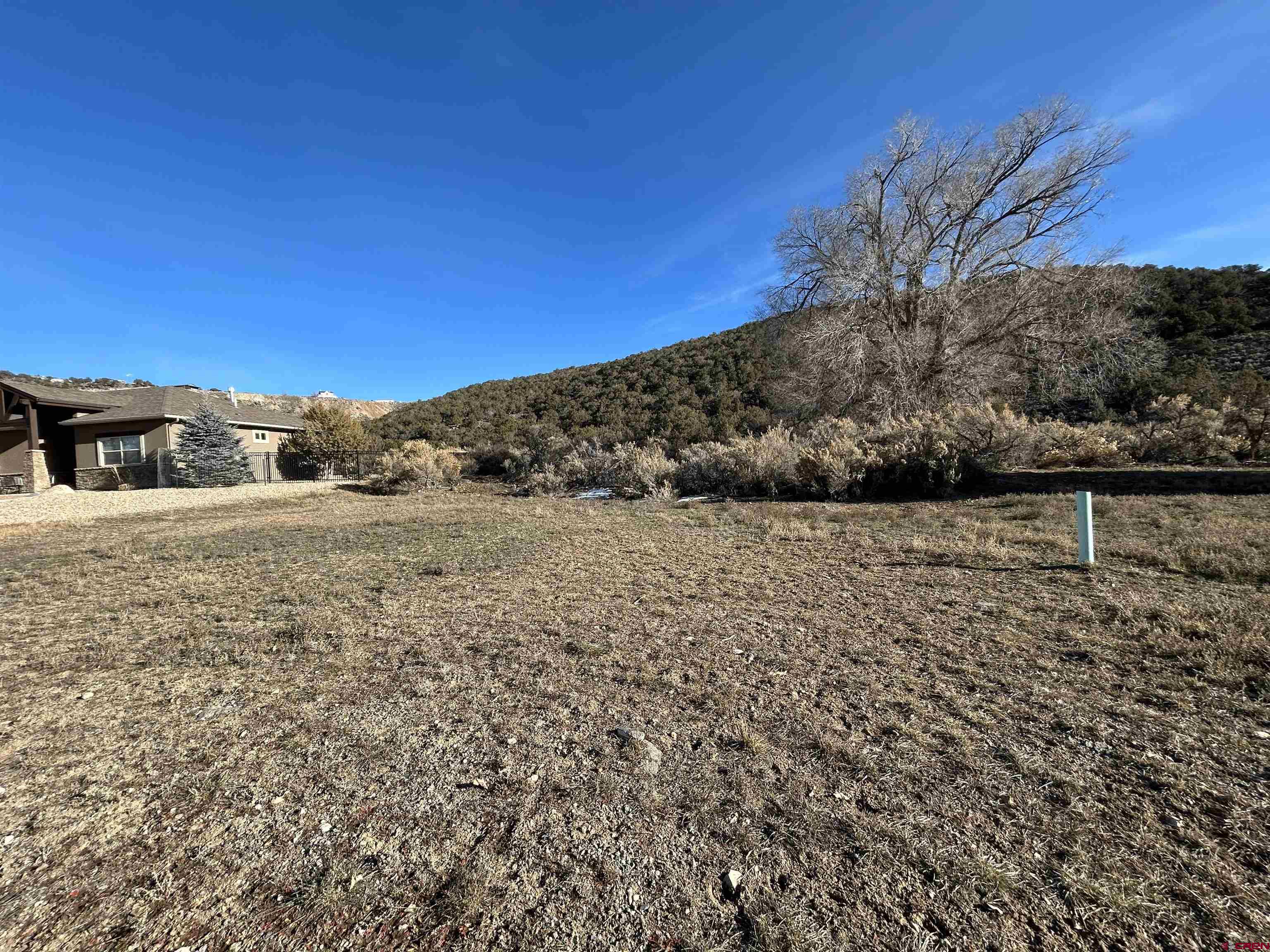 This 0.318-acre homesite is located in the sought-after Deer Creek Village Golf Course community in Cedaredge and offers an ideal setting for a custom home. The west-facing lot captures expansive views of the Grand Mesa to the west and north, while the non-buildable land behind the property provides lasting privacy and open space.  Enjoy walking-distance access to the Cedaredge 18-hole public golf course and the Surface Creek walking trail, along with convenient proximity to grocery stores, restaurants, and medical services. Delta Memorial Hospital is just 15 miles away. The Grand Mesa, less than 30 minutes away, offers year-round recreation including fishing, hiking, skiing, snowshoeing, and snowmobiling.  Surrounded by established homes and designed around the golf course, Deer Creek Village a very desirable neighborhood—offering a rare combination of views, privacy, recreation, and convenience.