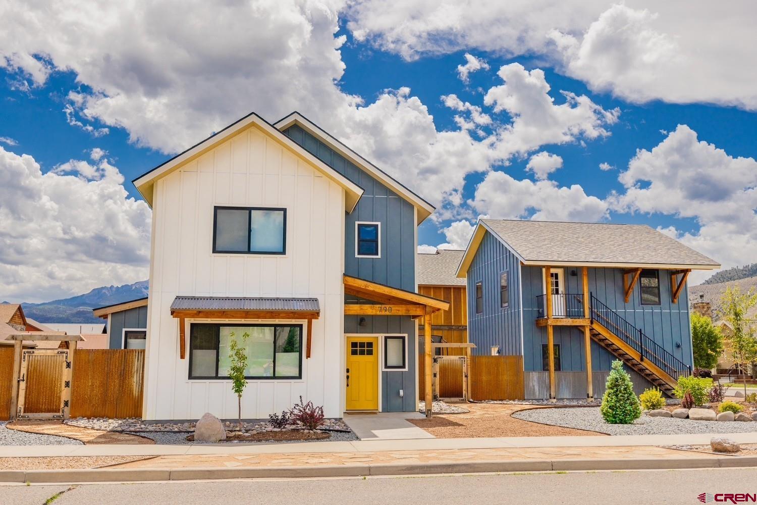 Exceptional Ridgway Home with Separate Guest Quarters-suitable for Short Term Rentals!  Discover a rare opportunity to own a thoughtfully designed Ridgway, Colorado home with a separate guest residence, perfectly positioned in the heart of Southwest Colorado’s mountain lifestyle. Ideally located for easy access to Ouray, Telluride, and endless outdoor recreation, this property offers the space, flexibility, and quality today’s buyers are searching for.  Unlike many new or nearly new homes that still require finishing touches, this residence is truly move-in ready. All landscaping has been professionally completed, fencing is in place, and the outdoor entertaining areas have been carefully designed for both privacy and enjoyment. Interior and exterior paint, trim, and finishes are complete—allowing you to begin enjoying mountain living immediately.  The main home is intelligently positioned away from the garage and upper-level 1 bedroom 1 bath unit, creating a sense of privacy and openness. The main level features a bright, open floor plan with expansive windows, rich finishes, and refined architectural details throughout. Flooring, lighting, metal accents, and custom design elements come together to create a warm yet elevated living experience.  The chef’s kitchen is a true centerpiece, offering custom cabinetry, abundant granite countertops, quality stainless steel appliances, and a striking gas range with custom hood—perfect for both everyday living and entertaining.  Outdoor living spaces are sheltered from sun and weather while maintaining separation from the guest quarters, allowing both owners and guests to enjoy privacy. The upper level of the main home includes a luxurious primary suite with a beautifully appointed bath, along with two additional bedrooms—one with a private bath and another with access to a shared full bath.  One of the most compelling features of this property is the separate guest home, finished to the same high standard as the main residence. It has been used as a very successful short term rental in the past, but it's ideal as a guest suite, home office, creative studio, or private living quarters, this space offers comfortable living areas, a generous bedroom, and a stunning bath with exceptional tile work. Whether used for extended family, visiting guests, or remote work, it provides unmatched flexibility.  Below the guest home is a garage and shop space, offering ample room for vehicles, gear, and all your Colorado toys. Parking is generous and adaptable, making hosting friends and family effortless.  If you’ve been searching for a Ridgway home near Ouray and Telluride that offers additional living space, guest quarters, extra income or a dedicated office or studio, without the need for remodeling or compromise, this property stands apart. Move in, settle in, and start enjoying everything Southwest Colorado mountain living has to offer.  Schedule your private showing today—this is a truly special home.