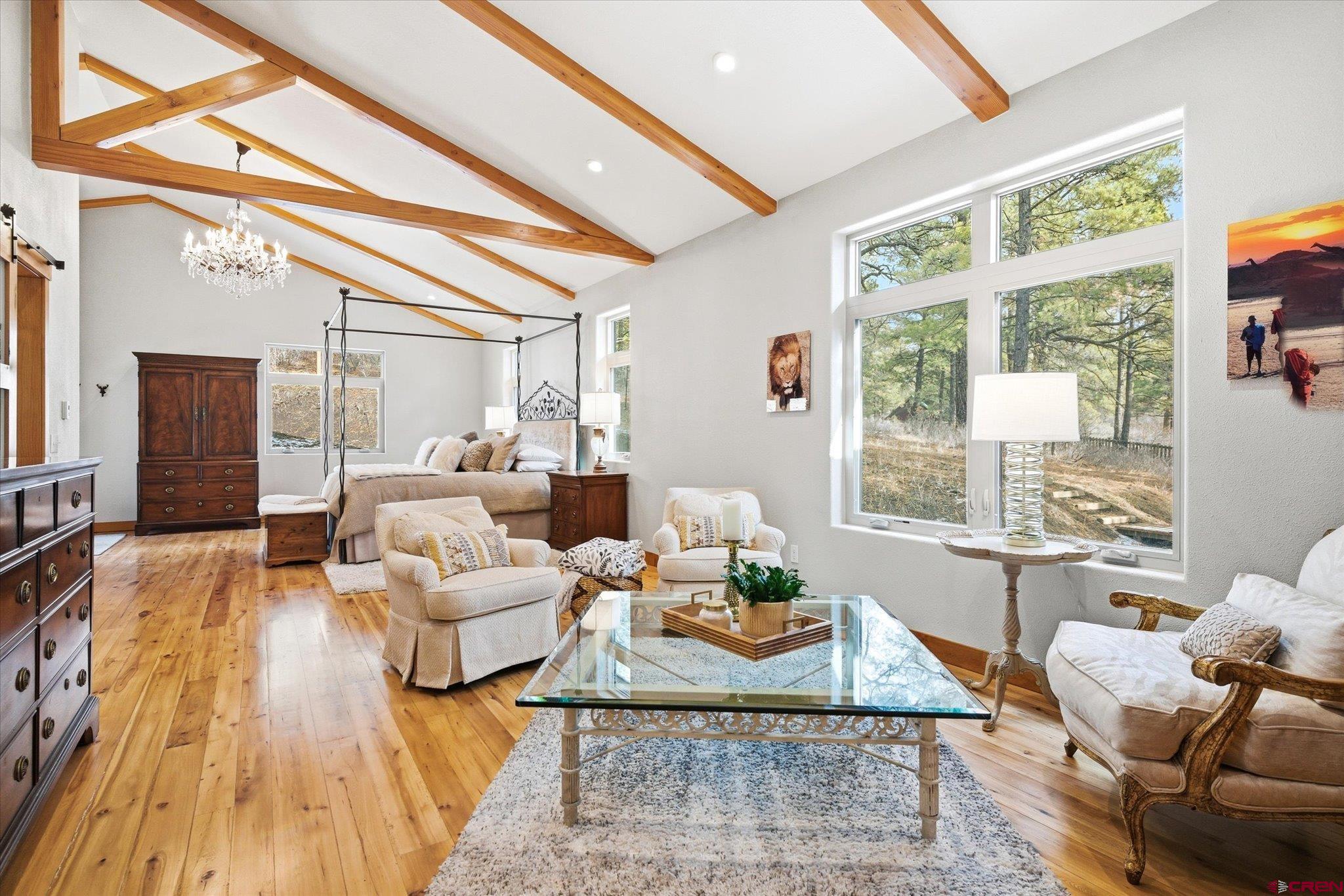 A rare blend of craftsmanship, creativity, and true Colorado living, this exceptional Pagosa Springs property offers more than a home. It is a thoughtfully designed residential compound created for year round comfort, entertaining, and enjoying the mountain lifestyle in every season. The main residence features radiant subfloor heating throughout, reclaimed rock elm hardwood flooring, and vaulted ceilings with exposed beams that bring warmth and architectural depth. Natural light fills the home through new Milgard windows, while custom finishes and carefully selected materials create a balance of sophistication and livability. The kitchen serves as a true centerpiece, anchored by a nine foot custom concrete island and a Kohler apron front farm sink. Black stainless KitchenAid appliances feature matching cabinetry panels, while a fully restored vintage O’Keefe and Merritt gas range in sapphire blue adds timeless character. A custom swing-up appliance garage provides a unique and functional design element. Industrial British bar stools, soft close hickory cabinetry, and Restoration Hardware and Emtek hardware complete the space. The primary suite offers a private retreat with vaulted beam ceilings, a stacked stone thermostatically controlled gas fireplace and dual French glass doors leading to a patio seating area. The spa inspired bath includes a forty square foot dual head shower, polished nickel fixtures, Robern backlit vanity mirrors, and a large walk in closet that connects directly to the laundry room for everyday convenience. A second 2,900 sq ft dwelling includes additional living space designed with flexibility and lifestyle. Upstairs includes a dedicated media room featuring an eighty-eight inch flatscreen with a Sonos sound system, a multipurpose room functioning seamlessly as a gym, yoga studio, or guest space including a Queen Murphy bed, and a full bath/shower with custom vanity. Downstairs includes an industrial automotive inspired diner. The diner features custom restaurant booth seating, a Kohler sink with Hansgrohe faucet, high end cabinetry with soft close drawers, solid butcher block countertops, subway tile with stainless trim, open shelving, and a secondary kitchen area ideal for entertaining, hobbies, or creative pursuits. Also downstairs is the 1,300 sq ft motorsports enthusiasts heated workshop and garage. The workshop sets this property apart. It includes two ten foot clear grid programmable garage doors, a dedicated 220v 60amp service for electric vehicle charging, a washer and dryer, a secure storage closet, and a powder bath. The concrete slab is 6 inches thick to permit lift installation with drains in each quadrant. Outdoor improvements have been thoughtfully designed for durability and functionality. The property includes concrete driveways with added drainage for rain and snow runoff, concrete walls and stairs, a gravel pass through drive, two gabion wall features, and a bioswale to aid drainage. Fruit trees include three apple and one apricot adding a productive and charming element to the landscape. Additional features include a large walk-in pantry, two tankless water heaters, two washer and dryer sets with one located in the main laundry room and one in the workshop, two refrigerators, extra utility sinks in the mudroom and workshop, custom designed vanities in three bathrooms, custom tile in baths, mudroom, and laundry, dual gas fireplaces, and a fully built out laundry facility with dual countertops, double sided cabinetry, drying station, linen storage, and a fold down ironing board. Every detail of this property reflects thoughtful design, quality construction, and a commitment to a lifestyle that values both beauty and function. Located in Pagosa Springs, this is a home designed for those seeking authenticity, craftsmanship, and true Colorado living. Total combined square feet of heated and usable space for both buildings is 5,390.