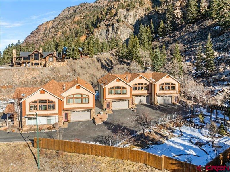 Exceptional luxury townhome offering privacy, views, and short-term rental potential in one of the most desirable locations in town. Walk out your front door to downtown, the Ouray hot springs, Uncompahgre River Trail and out your back door to access the Perimeter Trail. Designed for comfort and efficiency, this 3 bedroom plus office, 2 bath, 2 car garage home features in-floor radiant heating with smart controls, on-demand hot water, reverse osmosis system, water softener, a radon mitigation system and a SimplySafe security system. The South-facing sunroom/solarium showcases sweeping canyon and mountain views and dramatic sunsets, while multiple outdoor living spaces—including a shaded back deck and attached raised, private land xeriscaped for patio furniture under a shade tree facing the Canyon Wall—create an ideal retreat for owners and guests alike. It is an end- unit on the East side of the complex, providing a more peaceful and quiet living environment. This meticulously maintained property has had only two owners, has never been rented, and presents in turnkey condition. The HOA allows short-term rentals, and neighboring units demonstrate strong VRBO performance, making this an outstanding income-producing opportunity. Recent capital improvements include new stucco with a long-term warranty and a well-maintained roof with years of life remaining. Low-maintenance ownership is enhanced by HOA services covering exterior maintenance, landscaping of the shared fenced-in garden area, snow removal, insurance, trash, and driveway care. The home is offered fully furnished, allowing for immediate personal use or seamless short-term rental activation—an ideal luxury investment, second home, or primary residence.