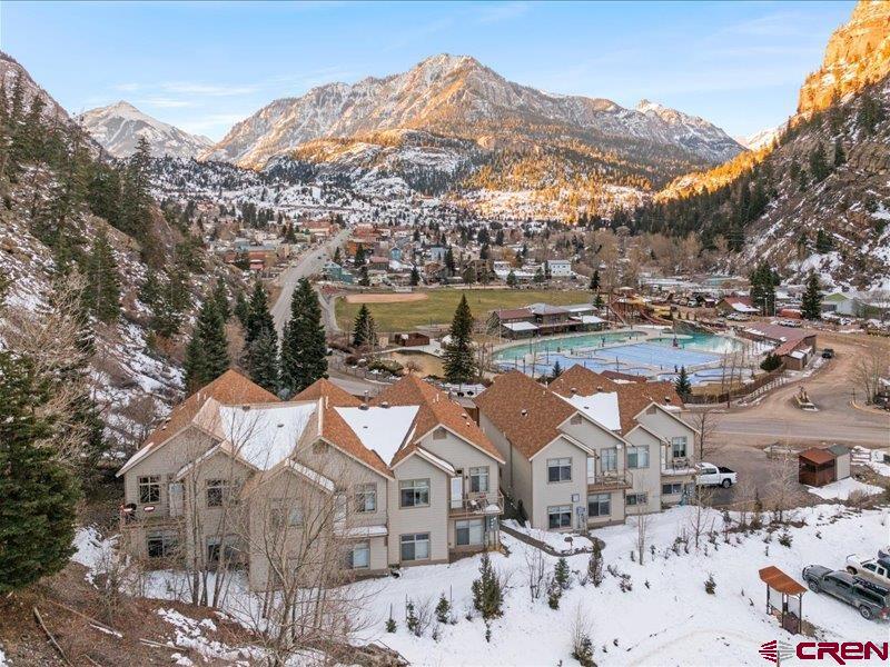 Exceptional luxury townhome offering privacy, views, and short-term rental potential in one of the most desirable locations in town. Walk out your front door to downtown, the Ouray hot springs, Uncompahgre River Trail and out your back door to access the Perimeter Trail. Designed for comfort and efficiency, this 3 bedroom plus office, 2 bath, 2 car garage home features in-floor radiant heating with smart controls, on-demand hot water, reverse osmosis system, water softener, a radon mitigation system and a SimplySafe security system. The South-facing sunroom/solarium showcases sweeping canyon and mountain views and dramatic sunsets, while multiple outdoor living spaces—including a shaded back deck and attached raised, private land xeriscaped for patio furniture under a shade tree facing the Canyon Wall—create an ideal retreat for owners and guests alike. It is an end- unit on the East side of the complex, providing a more peaceful and quiet living environment. This meticulously maintained property has had only two owners, has never been rented, and presents in turnkey condition. The HOA allows short-term rentals, and neighboring units demonstrate strong VRBO performance, making this an outstanding income-producing opportunity. Recent capital improvements include new stucco with a long-term warranty and a well-maintained roof with years of life remaining. Low-maintenance ownership is enhanced by HOA services covering exterior maintenance, landscaping of the shared fenced-in garden area, snow removal, insurance, trash, and driveway care. The home is offered fully furnished, allowing for immediate personal use or seamless short-term rental activation—an ideal luxury investment, second home, or primary residence.