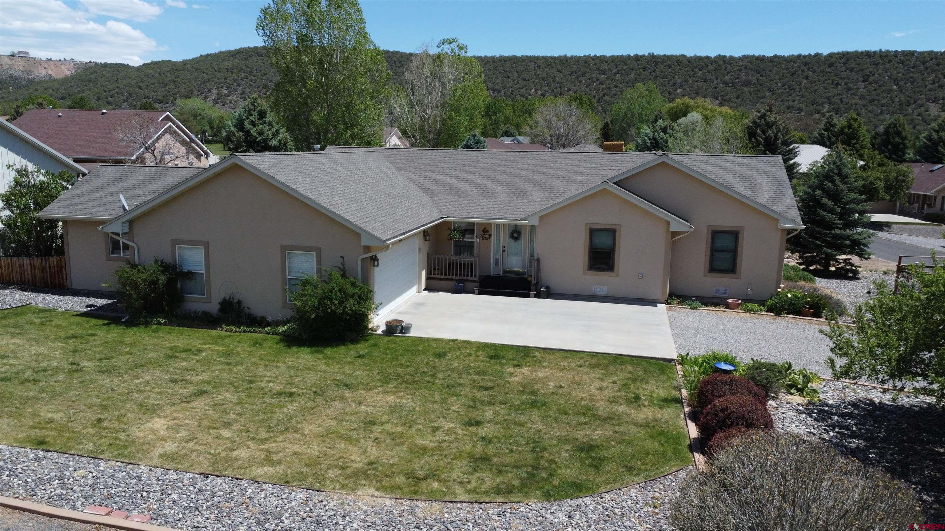 Welcome home!!! The 1661 sq. ft. 3 bed/2 full bath rancher sits on a corner lot at the Cedaredge Golf Course. Walking inside you will enjoy the beautiful open concept living area with cathedral ceiling and beautiful hardwood floors. Cast your eyes towards the kitchen and you will see the open kitchen complete with upgraded appliances, a nice island bar, and all topped with gorgeous granite countertops! On the other end of the house you will find spacious bedrooms that have had all new Anderson windows installed. The master bathroom is huge and has a make-up bench built in. If you take a peak into the laundry room your eyes will be drawn to the washer and dryer that are included with the home  The home has natural gas hot water baseboard heat. As you step outside onto the 22'x14' deck it is a seamless transition from indoor to outdoor living. Both deck covers are included in the sale which makes deck life much easier. The garden areas are fenced in and very enjoyable. The attached two car garage has a bonus room attached that is 14'x15’6” that makes storage in this house huge. The oversized  2 car garage is large enough to park a golf cart in and still store things or a perfect area to add more living space. This is a beautiful house in a great location.