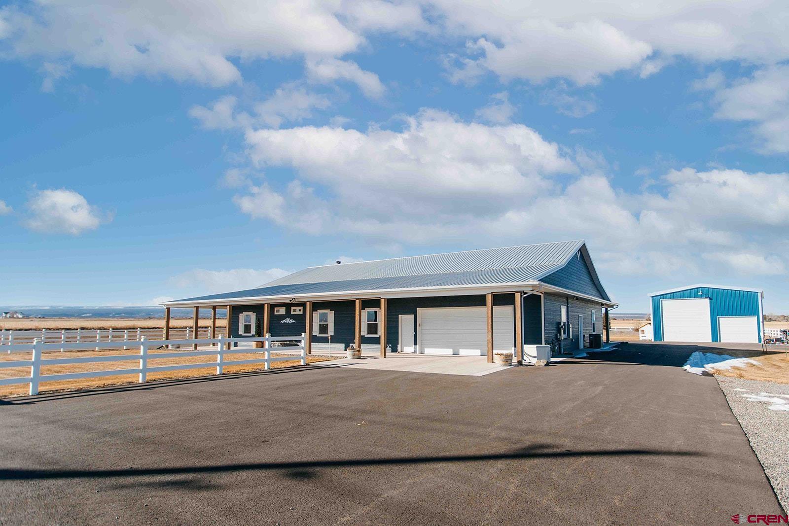 Stunning 2,700 sq ft main residence offering 3 bedrooms and 3.25 baths, featuring an attached 480 sq ft one-bedroom, one-bath ADU—for a combined 3,180 sq ft of thoughtfully designed living space on 1.27 irrigated acres, with no covenants or HOA.  The home features quartz countertops, double wall ovens, a separate gas range, and an oversized island with abundant storage—perfect for entertaining. The open-concept layout is enhanced by vaulted ceilings with recessed lighting set into exposed beams, creating a bright and inviting atmosphere.  The expansive primary suite is a true private retreat, featuring dual walk-in closets and a luxurious, five-star bath. A fully self-contained ADU with its own laundry offers exceptional versatility, with the potential for an additional ADU in the detached shop thanks to the already installed second permitted septic system; only county permitting would be required to complete the actual dwelling.  Equipped with Generac full-house generator, this property ensures uninterrupted power to the main home, ADU, and the impressive 30x40 shop as well as a separate shed. The attached 4-car drive-through garage adds convenience, while the shop easily accommodates a 5th wheel or motorhome, plus 2-cars, tractors, boats, or toys.  Enjoy a fully paved driveway, beautifully landscaped and fully fenced yard, and a 10x32 Planta greenhouse. There are also 5 fruit trees, raspberry and blackberry bushes — perfect for gardening enthusiasts.  Call today to schedule your private showing of this exceptional property!