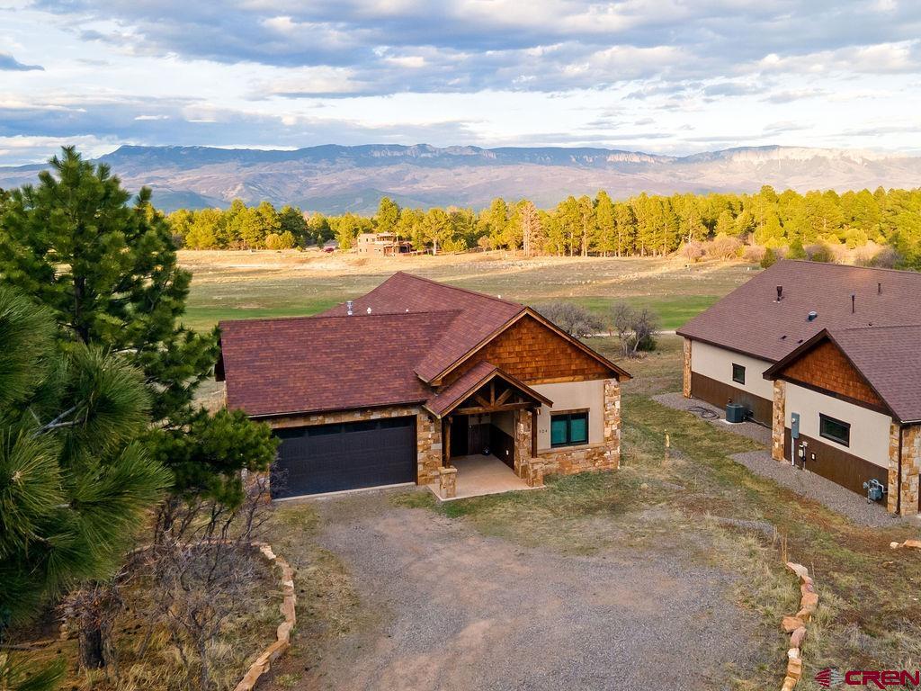 This cozy custom-built pied-a-terre in Fairway Pines Estates sits on the 1st fairway of Divide Ranch Golf Course, offering mountain and golf course views. It features 2 bedrooms, 2 bathrooms, high-end finishes, vaulted ceilings, and an open floor plan with abundant natural light. The kitchen includes granite countertops, stainless appliances, and knotty alder cabinets. The living area has a warm inviting fireplace, and the master suite offers spacious closet, and direct patio access. Enjoy outdoor living with a custom patio overlooking the Cimarron Ridgeline. Situated on the first fairway of the golf course, the home is an easy walk to the clubhouse. Large windows frame scenic views and wildlife. The home offers easy access to golf, hiking, skiing, and other recreation. Located near Ridgway, Ouray, Telluride, and Montrose, this property is ideal as a permanent or seasonal residence. Quality craftsmanship, thoughtful design, and numerous upgrades make it a standout mountain retreat.