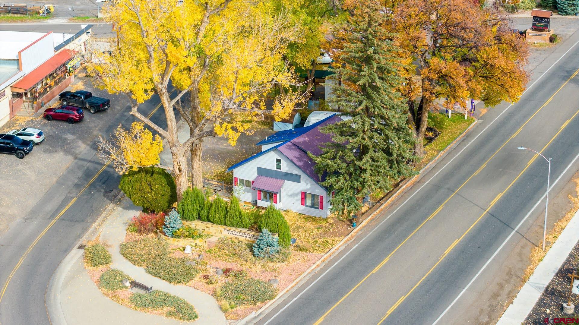 Live where Your Business is! This great spot for a Business also has Separate Living Quarters, so you can live right where your business is! Or you can rent it out if you like for more income! Positioned right on the main highway through Cedaredge, this charming Craftsman-style home is a rare gem that blends historic charm with exceptional commercial potential. With its classic architectural details, inviting presence, and prime visibility, this property offers endless possibilities in one of the town’s most desirable commercial corridors. Its prominent location ensures excellent exposure for any business venture while still maintaining the warmth and charm of a private residence. The main level, which encompasses 4 offices, 3 separate open room (reception type) areas, 2 Half Baths, a Kitchenette and a Laundry/Storage Room, offers an ideal layout for a wide variety of commercial uses. Imagine an art gallery showcasing curated and rotating exhibitions, a creative design or architecture studio with collaborative work zones, a boutique retail shop filled with unique finds, or even a cozy coffee shop or small restaurant that becomes a local favorite gathering spot. The warm, welcoming atmosphere makes it equally suited for a professional office—whether for consulting, wellness services, or other client-focused businesses seeking a comfortable, refined setting. Upstairs, a separate living quarters with 2 Bedrooms and one Full Bath provides incredible flexibility. An owner-operator can conveniently live above their business, creating the perfect work-life balance. Alternatively, the upper level can be rented out to generate additional income, maximizing the property’s investment potential. This property represents a rare combination of commercial opportunity and residential comfort within one charming building. It brings together culture, creativity, and small-business energy—an ideal fit for Cedaredge’s welcoming community and growing entrepreneurial spirit.