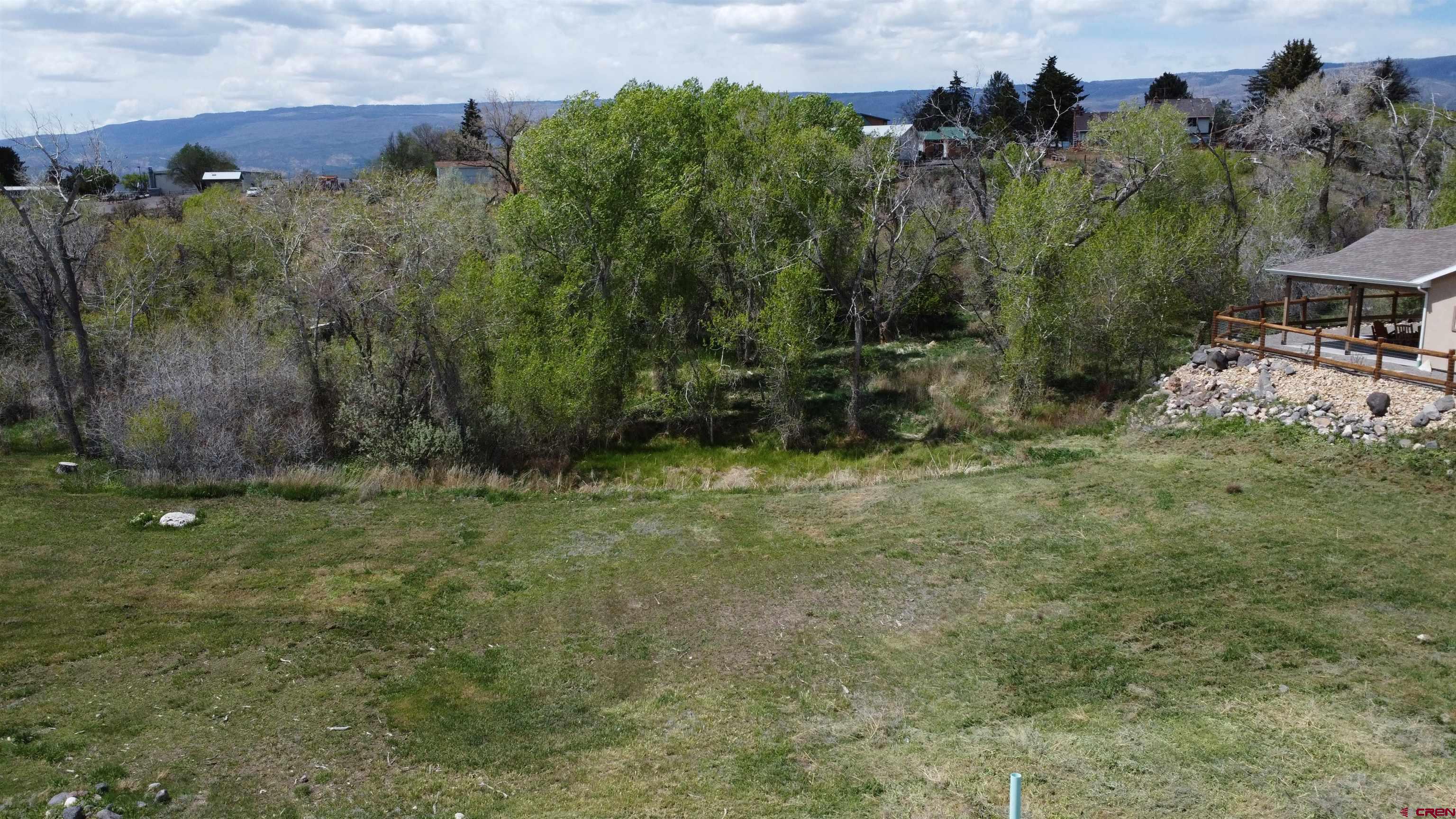 Build Your Dream Home in the Heart of Cedaredge! Discover the perfect blend of natural beauty and modern convenience with this stunning creek side lot in the highly desirable Stonebridge @ Deer Creek Village community. Nestled at the base of the majestic Grand Mesa, this 0.44-acre gem offers a rare opportunity to create your dream home in one of Colorado's most  picturesque settings. Imagine waking up to the soothing sounds of Surface Creek, with the walking trail just steps from your door. Tee off at the one of a kind Cedaredge Golf Course, practically in your backyard, or enjoy leisurely strolls surrounded by breathtaking views. This spacious lot has already been cleared, saving you time and effort, and ready for you to build your dream home starting this spring! Mature trees grace the back of the property, adding both privacy and charm. With gorgeous new homes being built all around, this is your chance to become part of an exciting and growing neighborhood. Convenience meets adventure here! Main Street's charming shops and the Grand Mesa Arts & Events Center are only a mile away. Plus, the Grand Mesa—home to over 300 lakes, endless hiking trails, camping spots, and year-round snow sports—is just a quick 20-minute drive up the road. This isn’t just a lot—it’s your gateway to an extraordinary Colorado lifestyle. Come enjoy and make your home in Cedaredge - The Gateway to Grand Mesa!