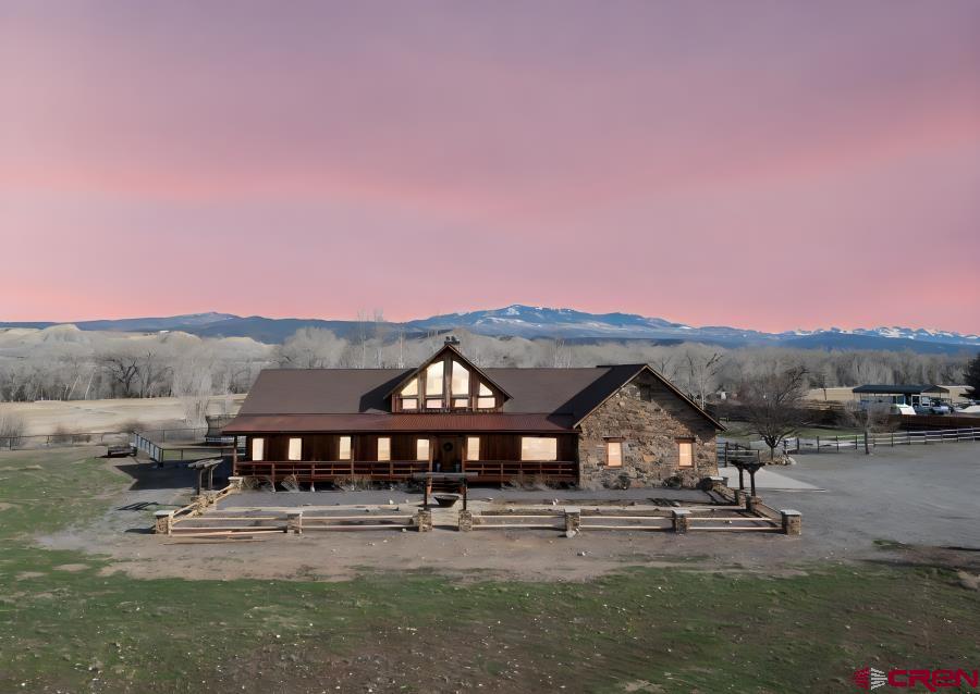 Every detail of this custom-built home has been thoughtfully crafted, evoking the charm of European architecture with textured walls, vaulted ceilings, and a stunning 2 story floor to ceiling, double-sided stone fireplace—perfect for cozy evenings indoors or fireside gatherings on the back covered porch. The cook’s kitchen is designed to bring everyone together, featuring a gas stove, double oven, two lighted pantries, and a large preparation island with a butcher block top. The concrete countertops add warmth and character, beautifully complemented by a large porcelain country sink, creating a space that is both functional and inviting for entertaining or everyday living. The backyard feels magical, offering sweeping views of Storm King Mountain framed by mature cottonwoods. A variety of birds bring a peaceful melody to the property, and bald eagles often grace the meadows beyond the fence—creating a serene sanctuary surrounded by nature. From the Primary Suite, step out through French doors to your private deck there is a hookup for a hot tub to sit beneath the stars. The primary bathroom offers a relaxing retreat with a jetted tub, perfect for soaking after a long day while enjoying the peaceful surroundings. Inside, the home blends elegance with practicality. The Primary bedroom is thoughtfully situated near the secondary bedrooms, offering peace of mind and comfort for families. Expansive windows fill the space with natural light, while the open layout invites warmth and connection. A huge upstairs loft with its own bathroom offers incredible versatility and privacy. This space could easily serve as a guest suite, home office, exercise room, or additional bedroom—perfect for visitors, remote work, or multi-generational living. The property offers abundant space and versatility. The front acreage is a blank canvas, ready to be irrigated for lush grass, gardens, or additional trees. A newly built pipe perimeter fence provides durability and security, while a fenced corral with a two-stall shed creates an ideal setup for animals or hobby farming. The spacious three-car garage includes dedicated work areas, offering plenty of room for projects, storage, tools, and recreational equipment. Additional storage throughout the home—including generous closets, large crawl spaces, and an attic above the garage—adds everyday convenience. If you’ve been dreaming of the perfect hobby farm just south of Montrose and only minutes from town, this property offers the ideal blend of rural serenity and accessibility. Set on expansive land with breathtaking views and endless opportunities, this home harmonizes elegance, function, and natural beauty—a true sanctuary for those who appreciate craftsmanship, privacy, and Colorado’s incredible landscape.