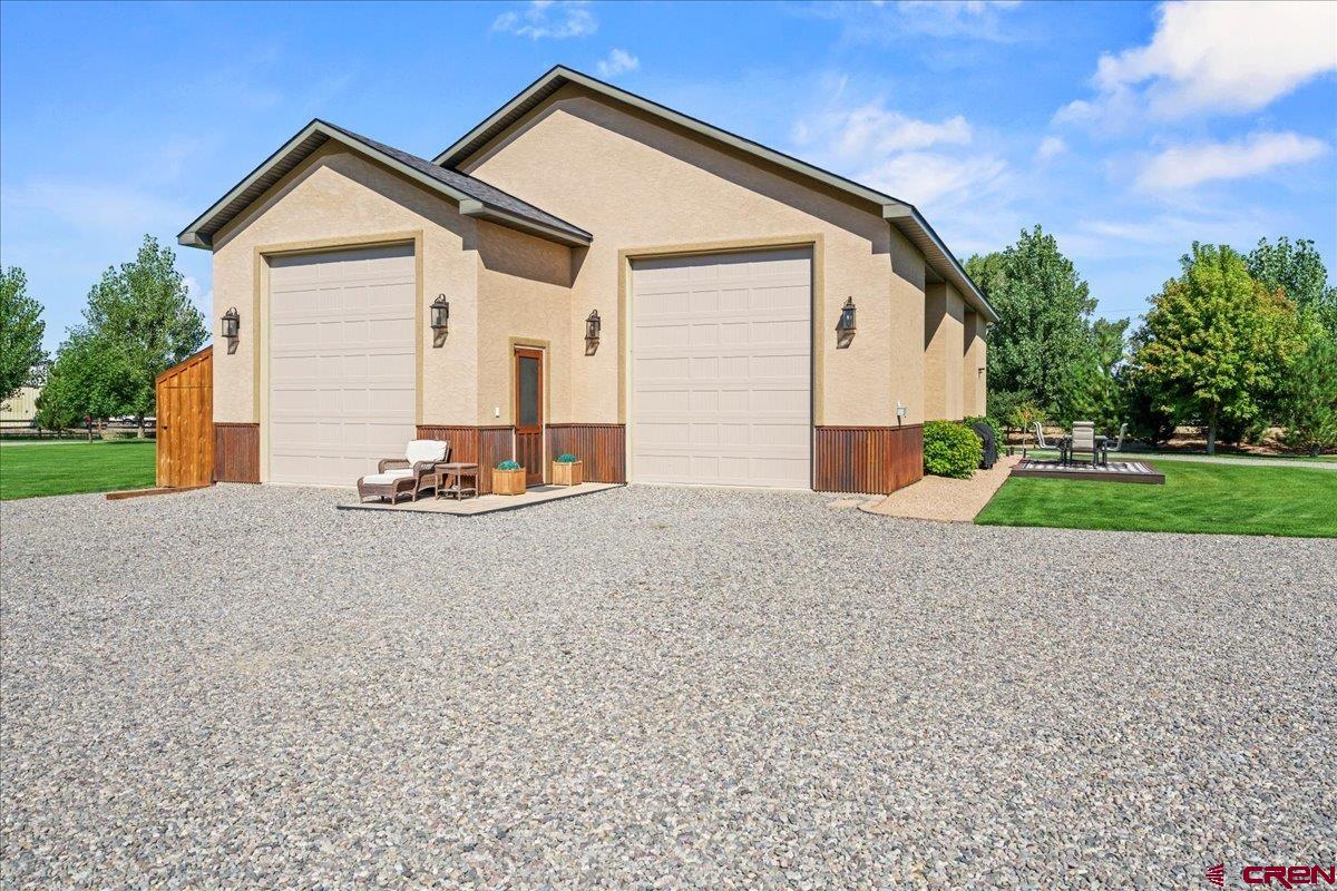 This personal retreat is a rare Colorado gem, offering a unique opportunity to enjoy today while planning for tomorrow. Nestled on two beautifully landscaped acres in one of the area's most desirable locations, this exceptional property combines immediate livability with the flexibility to expand, customize, or build your future dream home when the time is right. Unlike purchasing raw land, much of the hard work has already been completed. The property features a finished, versatile shop, thoughtfully designed one-bedroom, one-bath living quarters with additional flex space upstairs, established infrastructure, and meticulously maintained grounds. Whether you're looking for a peaceful retreat as it exists today or envisioning a larger custom residence in the future, this property provides an outstanding foundation. The expansive shop offers endless possibilities for personal hobbies, recreational storage, workshop space, or projects, while the comfortable apartment allows you to enjoy the property immediately. As your needs evolve, the generous acreage provides ample room to expand or create the home you've always imagined. The outdoor setting is truly exceptional. Every inch of the grounds has been carefully designed to create a private, park-like atmosphere where mature landscaping, lush lawns, vibrant flowerbeds, and thoughtfully placed lighting invite you to slow down and enjoy the surroundings. A state-of-the-art irrigation system keeps the landscape thriving throughout the seasons, while a beautifully illuminated pathway leads to one of the property's most memorable features—a custom-designed copper waterfall that flows gently next to an inviting fire pit gathering area. Whether you're searching for a beautifully maintained Colorado retreat, a property that offers room to grow, or a place where you can comfortably live while planning and building your forever home, this one-of-a-kind offering presents a rare combination of beauty, flexibility, and long-term potential. Properties that combine existing improvements, exceptional landscaping, and future building opportunities in such a desirable location are seldom available. Come experience the possibilities for yourself!