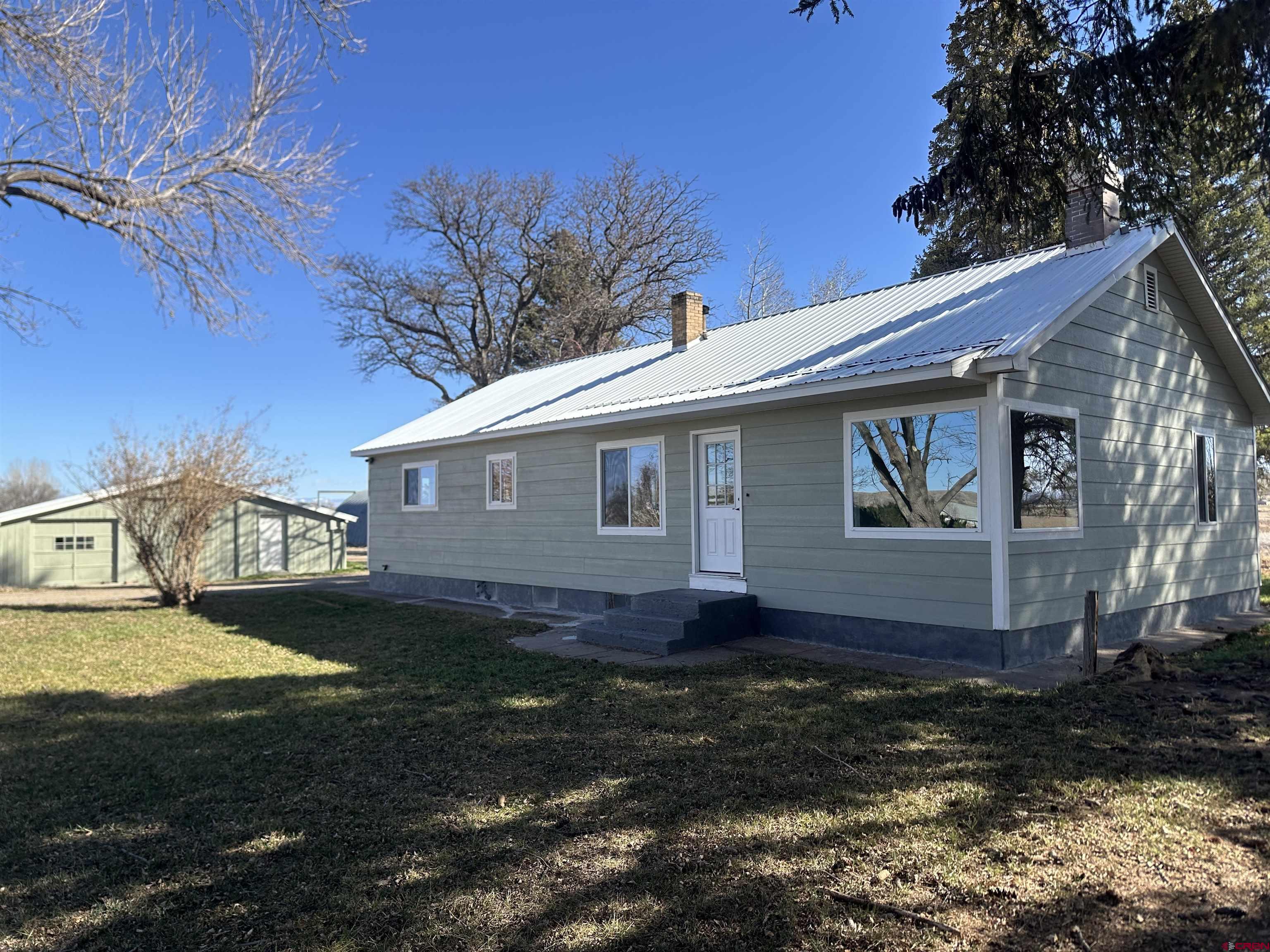 2.85 acres with a 2,056 sq.ft home and 60'x40' shop waits for you in the Coal Creek area! This home has many updates throughout including new siding, flooring, cabinetry, and bathroom vanities. The main level of the home is 1,456 sq.ft and has 3 bedrooms, 2 full bathrooms, wood burning fireplace in the living room, large windows to let in the natural light and to enjoy the valley around you. The primary bedroom has an attached full bathroom and two closet spaces for all your items. The kitchen has a dining space as well as island to enjoy your meals at. The basement of the home is partially finished, has two more bedrooms (non-conforming and approx. 600 sq.ft for the two rooms) and a storage space. Outside the home you will see mature trees, a covered back porch space, a large 60'x40' shop with concrete floors, 220v and entrances on both ends so you can drive through. There are also two silos as well as a workshop area and storage space in the building next to the home. The property has enough room for you to have your animals, privacy and it is in close proximity to BLM and all the outdoor recreation you can dream of!