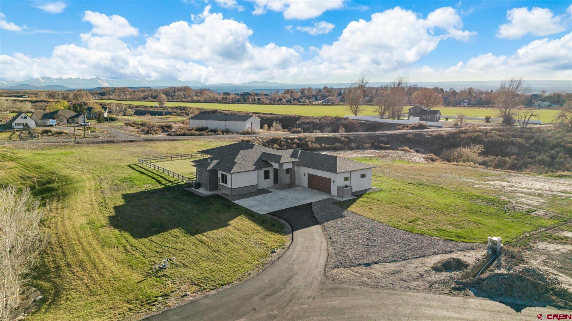 BETTER THAN THE PHOTOS! Majestic Mountain Views on acreage. A unique property, exceptionally clean and meticulously maintained in a childfree household. The 2.3 acre lot feels larger alongside the neighborhood greenspace and natural arroyo. Built by Coker Homes, with unmatched workmanship and finishes, inside the walls and out! Completely customized and filled with natural light. Oversized Enerlux gallery windows spanning south facing wall wrap provide 270 degree views capturing the absolutely epic San Juan and Cimarron Mountains, sunrises with the back drop of a magnificent oak tree and fiery red sunsets. Hand-crafted, Amish Wood cabinetry invite the sky and sunshine to expand throughout the kitchen. Upgraded with mostly drawers, a double thick quartz top, glass subway tile backsplash that shimmers and an expansive island. The en-suite is oversized and the primary bath pops with natural light. Complete with a serene ergonomic soaking tub, a huge, tiled walk-in shower and a completely custom matching walk-in closet. Two oversized guest bedrooms each with walk-in closets and a small bonus room for a home office, nursery or gym. The laundry/mud-room is refined with custom designed counter-height tiled clothes pre-rinse or dog wash station for ease when returning home from a fun adventure. Extra closets throughout the home. The garage accommodates larger trucks, toys, and tinkering, with an 18’ door, extra depth and width, with heightened ceilings and windows. The oversized, extended covered and lit back patio is the perfectly oriented to block harsh summer rays while inviting in the lower winter sun. A home like this is hard enough to find on its own, much less when it’s on 2.3+ irrigated acres, tucked between two creeks and open space to make it feel even more expansive without the added maintenance. Upgrades include a Warmboard, 4-zone radiant heat system with a 2-zone A/C system, Hellenbrand Whole House Promate Water conditioning system, Hunter Douglas mechanized blinds, over-excavated foundation with a full French drain setup and conditioned crawlspace, upgraded drywall and insulation, 10’ ceilings and so many more. The Falls at Valley Ranch is perfectly placed just minutes from all the best of what Montrose has to offer; a budding restaurant and brewery scene, unmatched healthcare, trails, open space and parks, boutique and traditional shopping, all without the headache and drama of what you get with urban living. Experience 3802 Aspen Grove for Yourself Today!