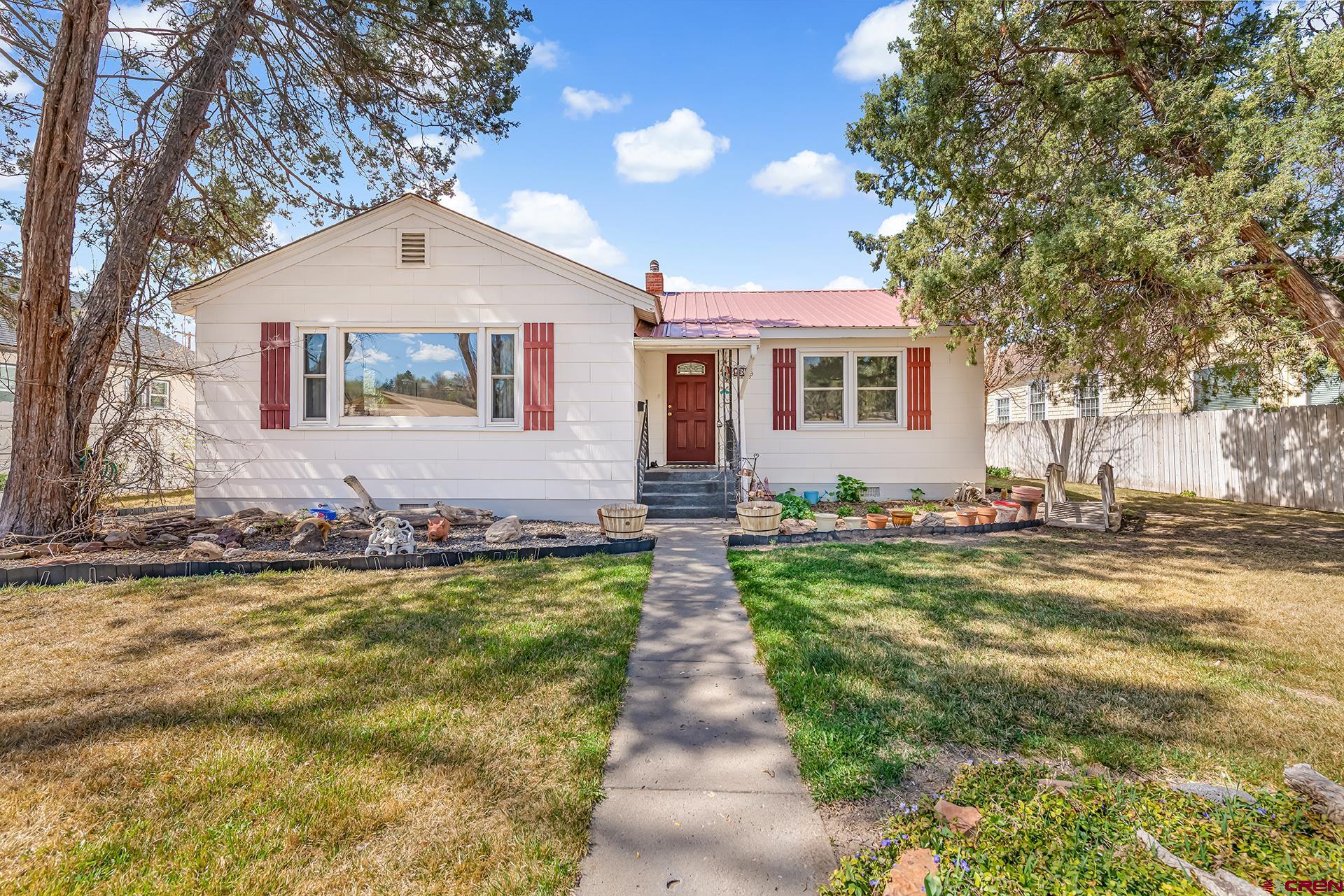 Charming 1,629 sq ft home ideally located across from Cleland Park. This inviting 2 bedroom, 2 bath home showcases original hardwood floors throughout. Enjoy generously sized bedrooms, a dedicated dining area, and a spacious laundry room complete with sink and built-in storage. The remodeled kitchen and bath add modern comfort, while a versatile bonus room; featuring a 3/4 bath, closet, and cozy wood stove, can easily serve as a third bedroom, guest suite, or home office.  Situated on a quarter-acre lot, the property provides ample space for RV parking, additional vehicles, gardening, and outdoor pets. Mature trees, well-maintained landscaping, nice lawn areas, and multiple outbuildings enhance the appeal, along with a detached one car garage, metal roof, and fenced backyard.