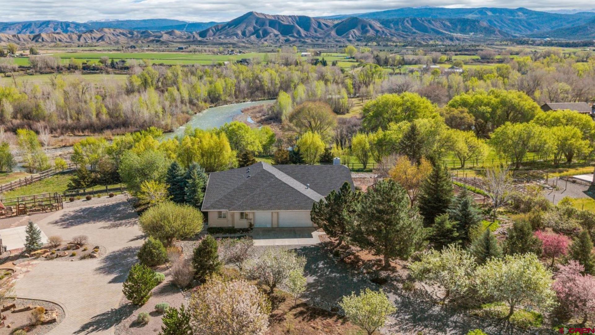 Custom, Sprawling Ranch Home on Over an Acre with Irrigation Water, Massive Garage, Garden Paradise, Wildlife Wonderland, and Private River Access Around the Corner! Are you looking to come home to gorgeous hardwood floors, accented by spectacular natural light and an open concept floor plan? This curated, 1-owner home delivers everything you're looking for. The kitchen is equipped with a huge island with an additional sink, a large walk-in pantry with tons of storage, an ergonomic layout, and plenty of counter space. The kitchen/living/dining trio are oversized and would make entertaining and hosting your loved ones a breeze. The en-suite includes custom features such as a vault ceiling, a bonus flex area, perfect for a home office, yoga mat, or reading nook, and private access to the magical backyard. The en-suite bath has a spacious and easy-to-use walk-in shower, great natural light and views, as well as a 2 roomy vanities. Enjoy all the flexibility in the world with two additional guest bedrooms, as well as flex room spaces, perfect for crafting and tinkering, a playroom or a home gym. A laundry room complete with a sink and additional cabinetry is the perfect place to keep the mess out of sight. The benefits continue with the garage of your dreams, which is an oversized, 3-car setup with additional room for another vehicle or the perfect setup for a workshop. Just imagine, you now have room for all the projects, room to spread out, and space to enjoy and store all your toys and hobbies. Step outside to what could be the best feature of this already impressive offering; majestic views of the mountains, bordering open space, a beautiful, lush garden oasis just waiting to deliver all the peace and tranquility you've been looking for, and the literal sound of the Uncompahgre River serenely slipping by as you sit down on your expansive porch, favorite beverage in hand, and realize that this is the good life! Golden delicious apples, pears and apricots, raspberries, cherries and strawberries, plums, thyme, too many to list! Exclusive river access and trails lie around the corner from this home, and the excellent location of the River's Edge subdivision delivers quick access to all of the best amenities Montrose has to offer, as well as great proximity to the unmatched and largely undiscovered frontiers of the San Juan Mountain Range with endless recreation opportunities. An Exceptional and Well-Loved Home, An Elevated Life in an Incredible Location, And A Life of Adventure and Beauty Await You; Experience it For Yourself Today!