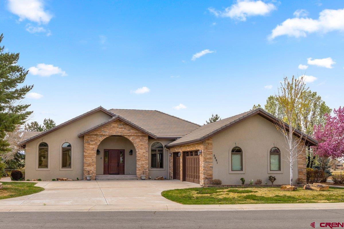 Luxury living at its finest in one of Montrose’s most desirable golf course communities. Perfectly positioned along the fairway, this exceptional residence offers an ideal blend of elegance, comfort, and thoughtful design.  This beautifully appointed 4-bedroom, 4-bath home showcases refined finishes throughout, including newer wood flooring, tile, and plush carpet. Designed for both everyday living and entertaining, the home features two spacious living areas anchored by a striking rock fireplace, along with a formal dining room for more intimate gatherings.  The gourmet kitchen is truly a chef’s dream, boasting abundant updated cabinetry and pantry space, granite countertops, a 6-burner gas cooktop with vented hood, double ovens, and a built-in microwave—perfectly suited for both casual meals and elevated entertaining.  The primary suite is a private retreat, offering generous space for a sitting area and serene views of the golf course. The fully remodeled primary bath exudes luxury, featuring custom mirrors framed in cultured stone, a soaking tub, an expansive walk-in shower, and a large walk-in closet designed for two.  Functionality meets convenience in the well-equipped laundry room with utility sink and built-in ironing station, located just off the oversized, finished, and heated 3-car garage complete with workbenches and custom metal cabinetry.  Outdoors, the meticulously landscaped grounds create a true sanctuary. Mature pine trees and vibrant flowering shrubs frame the expansive backyard, while the outdoor living space is designed for year-round enjoyment. Relax or entertain on the large Trex deck with pergola, gather around the fire pit, unwind in the hot tub, or enjoy the soothing rock water feature. The fully equipped outdoor kitchen completes this exceptional setting.  This is a rare opportunity to own a stunning golf course home  that embodies luxury, comfort, and Colorado living at its best.