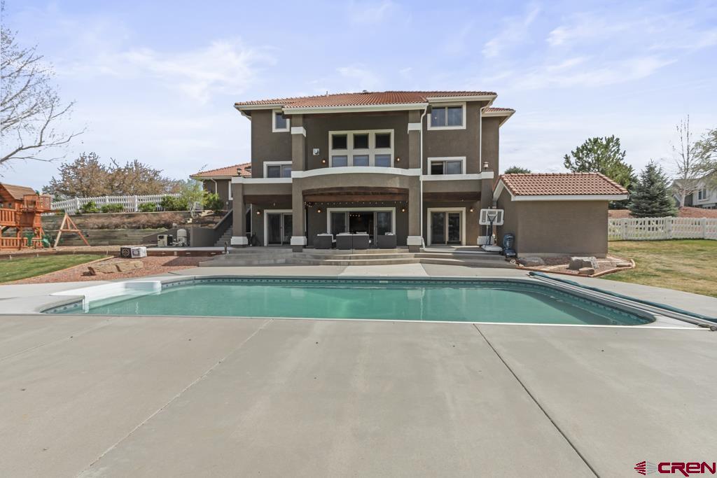 Nestled on just under two acres in the highly sought-after Solar Hills Ranch community, this exceptional residence offers refined living with breathtaking views of Montrose. Thoughtfully remodeled and boasting over 4,400 square feet of beautifully finished space, this home seamlessly blends comfort, style, and functionality. Designed with both everyday living and entertaining in mind, the home features expansive indoor and outdoor gathering spaces. The heart of the home is a centrally located kitchen that opens to the main living area, flanked by a formal dining room on one side and a bright breakfast nook on the other. Step out from the nook onto the elevated balcony to take in sweeping views of the valley and your own private backyard retreat. Outdoors, you’ll find a true oasis—complete with a sparkling oversized in-ground heated pool, custom playground, pool shed, and a generously sized covered patio perfect for relaxing or hosting. The beautifully landscaped grounds also feature a multi-level garden terrace ready for your personal touch, and space for a detached second building, all supported by HOA irrigation to keep everything lush and green. Inside, the home offers four spacious bedrooms, a dedicated office/5th bedroom, three full bathrooms, a powder room, and a grand laundry room with expansive storage. The walkout basement provides additional flexibility with a large family room, office space, and a full kitchenette—ideal for guests or multi-generational living. Two built-in Murphy beds further enhance the home’s ability to comfortably accommodate family and visitors. Situated at the end of a quiet cul-de-sac, this property offers peace, privacy, and stunning mountain views, all while being just minutes from town. Whether enjoying a quiet morning walk or hosting unforgettable summer gatherings, this home is designed to be both a personal retreat and a place where memories are made.