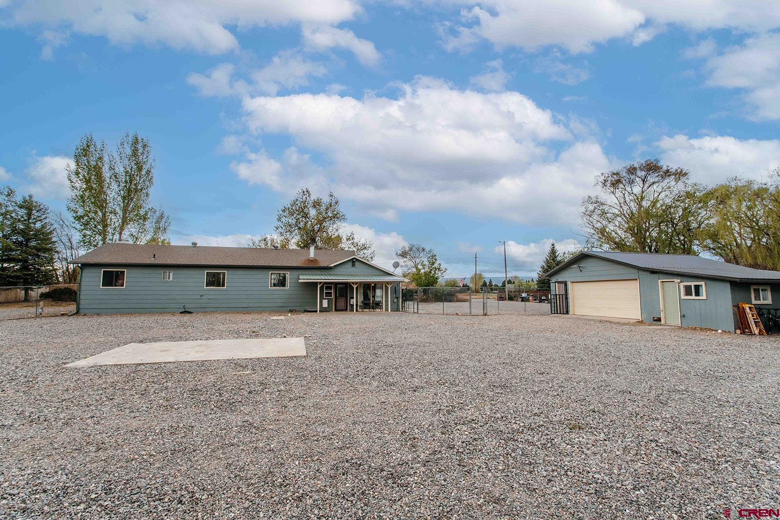 Tucked along Spring Creek Road, this unique Montrose property offers a rare blend of accessibility and surprising tranquility. While conveniently located 2.7 miles from main street, the backyard feels like a private oasis, quiet, secluded, and perfect for relaxing, entertaining, or enjoying Colorado’s natural beauty without the noise. The home has been partially updated (new flooring in the kitchen and living areas and new dry wall in the entry way), offering a solid foundation while still leaving room for your own improvements and personal style. All appliances have been replaced within the last three years, providing added value and peace of mind. The home also offers a basement with built-in shelving adding plenty of practical storage space. Outside, the property truly shines. Fully fenced for privacy and security, it features five outbuildings, a dedicated dog run, and plenty of space for hobbies, storage, or animals. A standout feature is the large shop, complete with a fully insulated attached space. Ideal for a workspace, studio, or year-round projects separate from the main shop area. Irrigation water is provided through the HOA, helping maintain the landscape with ease. Enjoy a variety of established fruit trees, including apple, apricot, cherry, and more. Adding charm, shade, and the opportunity for homegrown harvests right in your own backyard. If you’re looking for a property with space, versatility, and a peaceful backyard setting that defies its location, this one is worth a closer look.