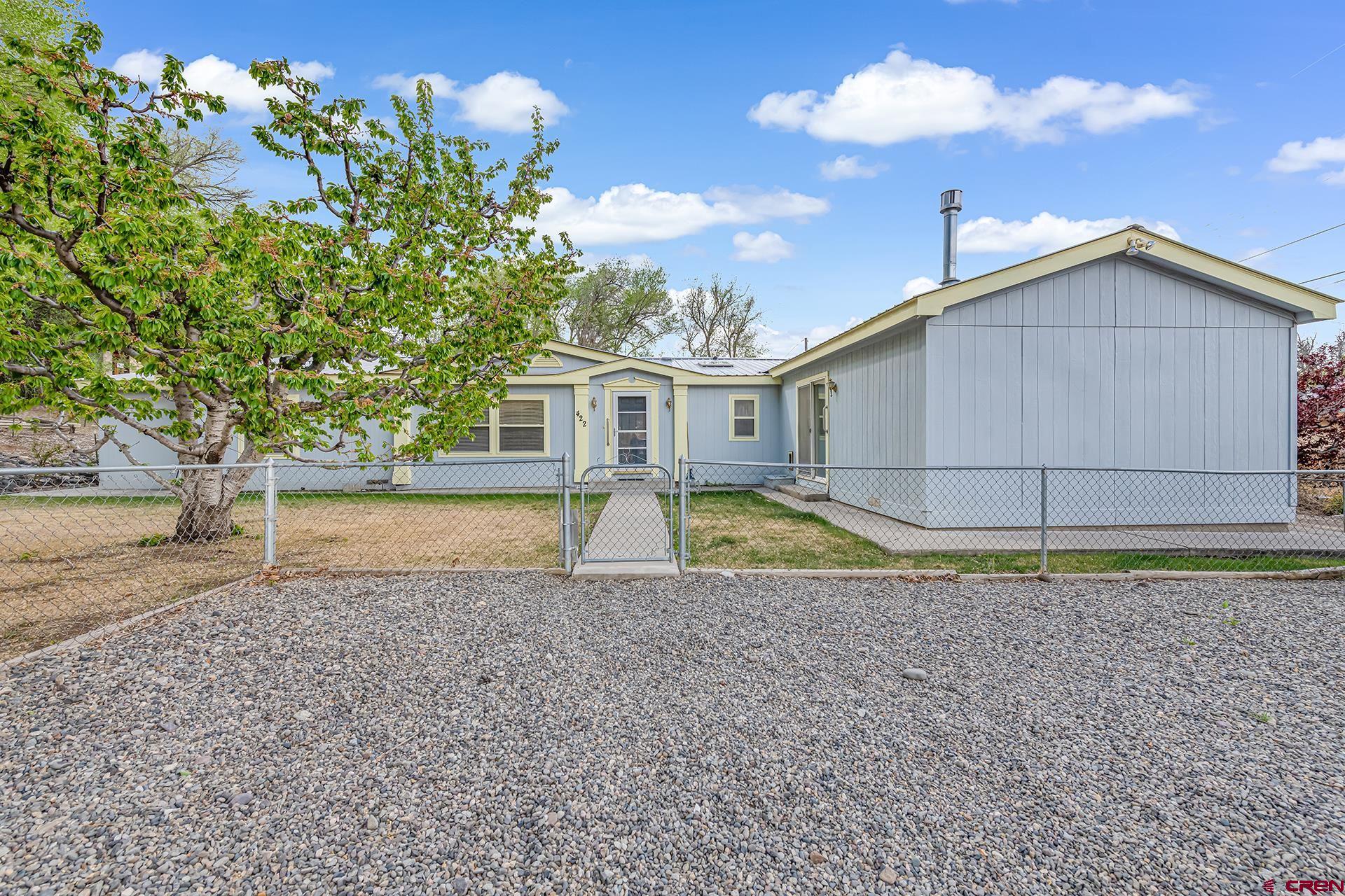 Tucked away where 5th St. ends at the hill and meets the Garnet Mesa walking trail this property has a lot to offer from a spacious 1953 sq. ft. manufactured home built in 1995, to a fenced yard on sprinkler with impressive mature trees and landscaping. Massive Rose bushes, Aromatic Lilacs, and Beautifully shaped old cherry trees that still produce well adorn the home. Sidewalks all the way around with large covered back patio/carport. Metal roof, Garden shed, and plenty of parking. 3 bedroom and 2 bath with a split floorplan and large master with a 16x22 addition and 5 piece master bathroom and walk in closet. Separate office room. Natural gas forced air and central A/C in main portion with a freestanding gas stove and mini split in the addition for heating and cooling. Home has been purged to the property and sits on an overbuilt concrete foundation with traditional stem wall. Within a short walk to Main St. and downtown amenities don't miss out on all this property has to offer.