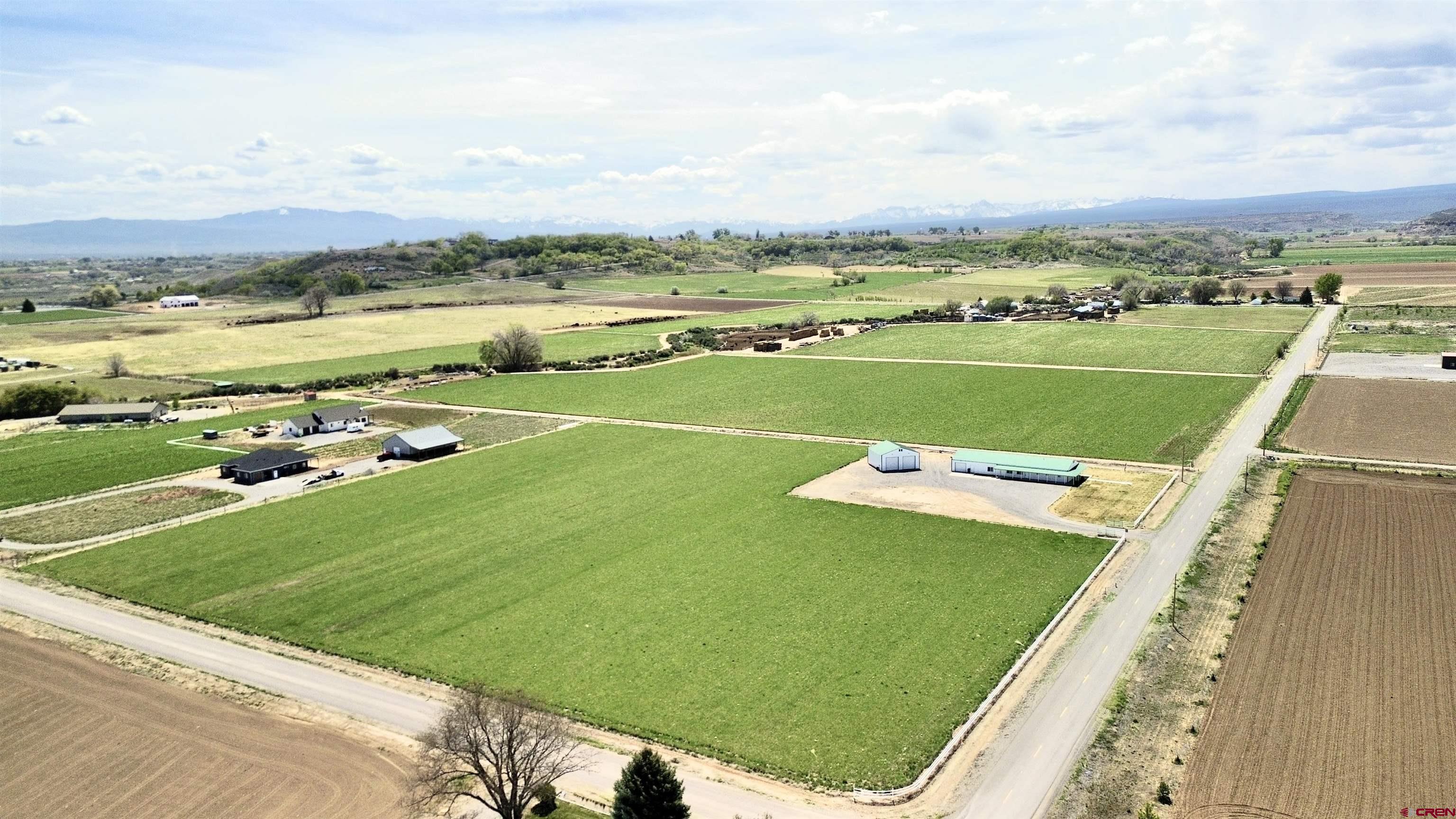 Situated on 9 acres in the beautiful Coal Creek area, this unique property offers unparalleled freedom and endless potential just minutes west of town. With no restrictive covenants and an HOA solely to administer irrigation water, this is a rare opportunity to curate a premier hobby farm, equestrian estate, home-based business, or a private hobbyist’s paradise. The primary structure spans over 3,000 square feet and features a two-bedroom home with an open floor plan and fresh interior paint, The bright kitchen includes all appliances, plus a washer and dryer, while the living room and bedrooms are equipped with ceiling fans for year-round comfort. Complementing the living quarters is a massive, attached, and heated 6+ car garage and workshop area. This space is fully outfitted with multiple work zones, a half bath, a kitchenette, and a utility sink.  One could convert some of the space to enlarge the living space, if desired. For those needing even more room for equipment or livestock supplies, the property includes an additional 1,296 square foot detached shop. Outdoor living is a highlight of this estate, featuring a charming wrap-around porch perfect for relaxing and taking in the expansive skyline. The acreage is highly functional for agricultural use, with gated pipe included to simplify land maintenance and irrigation. Whether you envision a high end horse facility, a multi use workshop compound, or room to build another home, this versatile Coal Creek gem provides the space and infrastructure to bring your vision to life.