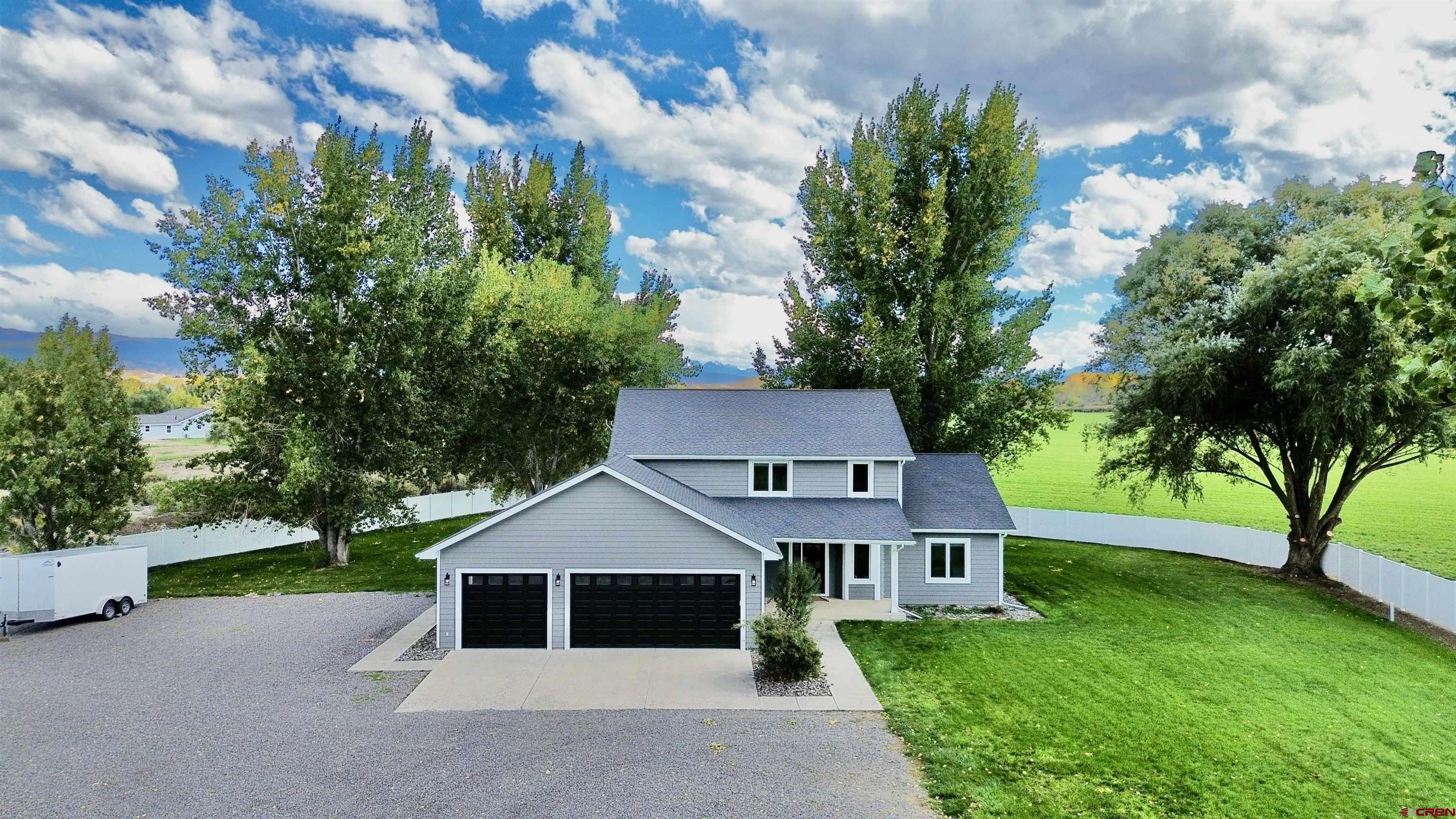 Spacious, updated in-town home on 1 acre with no HOA, no covenants, and beautiful mountain views. With nearly 3,000 square feet, 4 bedrooms, and 2.5 baths, this home offers the space you want with the peaceful feel of a rural setting. Large windows fill the home with natural light, while mature trees and surrounding views create a setting that feels private and open at the same time. The kitchen is a standout, featuring brand new stainless appliances, quartz countertops, abundant cabinetry, a pantry, and a functional bar that opens seamlessly to the dining and living areas. Just off the dining space, step onto the expansive covered patio, perfect for entertaining or enjoying quiet Colorado evenings year round. The main level primary suite offers a true retreat with a spacious layout, soaking tub, tiled shower, double vanity, and a large walk in closet. Upstairs, you will find three additional bedrooms, a generous second living area, and a well appointed bathroom with a tiled shower, giving everyone room to spread out. Additional features include a dedicated laundry room with new washer and dryer, a convenient half bath, and plenty of storage throughout, including oversized closets and under stair storage. The three car garage with keypad entry, along with extra space for RV or trailer parking, adds even more flexibility. With no HOA or covenants, you have the freedom to truly make this property your own, whether that means adding a shop or simply enjoying the extra space. Located on the desirable south side of Montrose, you are just minutes from schools, shopping, dining, and the Montrose Recreation Center while still enjoying a quieter, more open setting. This home offers the rare combination of space, updates, and flexibility all in one property.