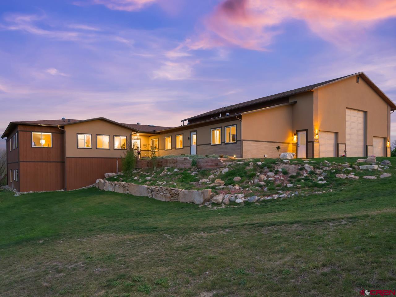 Some properties make a quiet case for themselves - and this one in Montrose's Southview neighborhood makes it convincingly. Sitting on 1.5 acres at the end of a cul-de-sac with views stretching out in every direction, this 2021-built, ICF construction, 7,266 square foot ranch is designed for living large while keeping everyone close - a genuinely well-thought-out multigenerational home with three fully equipped separate living spaces and room for every season of life. Step inside and the composite wood floors and vaulted ceilings set a warm, quality tone immediately. The living room is anchored by a two-way gas fireplace - equally at home facing the living space or the breakfast nook beyond, creating a natural flow between the two. The kitchen is practical and characterful with butcher block counters, a large butler's pantry, and counter seating. A dedicated office with deck access gives working from home an unexpectedly pleasant backdrop, and the formal dining room handles the larger gatherings with ease. The primary suite is well-proportioned with a five-piece en-suite that includes a jetted tub, walk-in shower, and walk-in closet. Two additional main-level bedrooms share a pass-through bathroom - a smart layout that gives everyone their own space without anyone feeling shortchanged. A loft sits just past the laundry, adding one more flexible layer to an already adaptable floor plan. Now for the extras that make this property genuinely rare. The main-level additional living space offers a private living room, bedroom, bathroom, and kitchen - ideal for guests, aging parents, or multi-generational living arrangements. The basement living space goes further - three bedrooms (one non-conforming), a full bath, kitchen, and living area that functions as a completely independent residence. The unfinished portion of the basement is ready to become a workshop or studio, and the attached garage - oversized enough to house an RV with room to spare - includes its own workshop space as well. Outside, a terraced yard with garden space, a private pond, and a pergola-covered deck with those sweeping views complete a property that simply doesn't have many comparisons. Come see it today.
