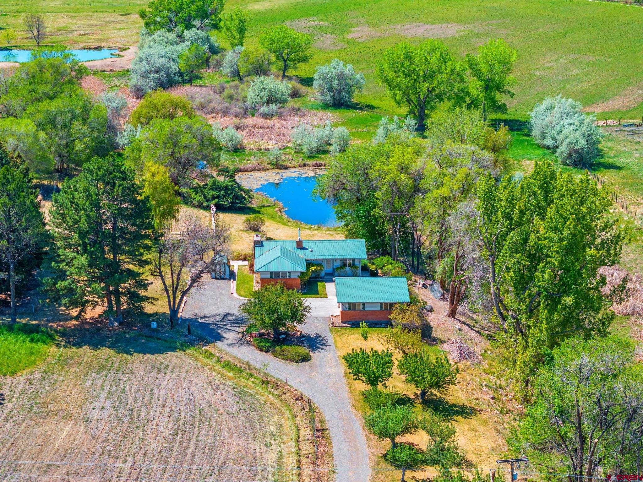 Nestled on 5 breathtaking acres, this stunning property offers the perfect blend of peaceful country living and outdoor adventure. The centerpiece of the property is a large, beautiful pond complete with a dock and plenty of space for kayaking, swimming, and fishing. Once home to a zipline stretching across the water, this property is truly designed for making memories.  Surrounded by gorgeous mature trees and mountain views, the back porch provides the perfect place to relax and take in the incredible scenery overlooking the pond. The property also includes a fenced enclosure ideal for horses or other ranch animals, making it a dream setup for equestrian lovers or anyone seeking a private rural retreat.  Inside, the home features 4 bedrooms and 2 bathrooms with comfortable living spaces filled with natural beauty just outside every window. Whether you're looking for a family homestead, hobby ranch, or serene getaway, this one-of-a-kind property delivers unmatched charm, recreation, and country elegance.