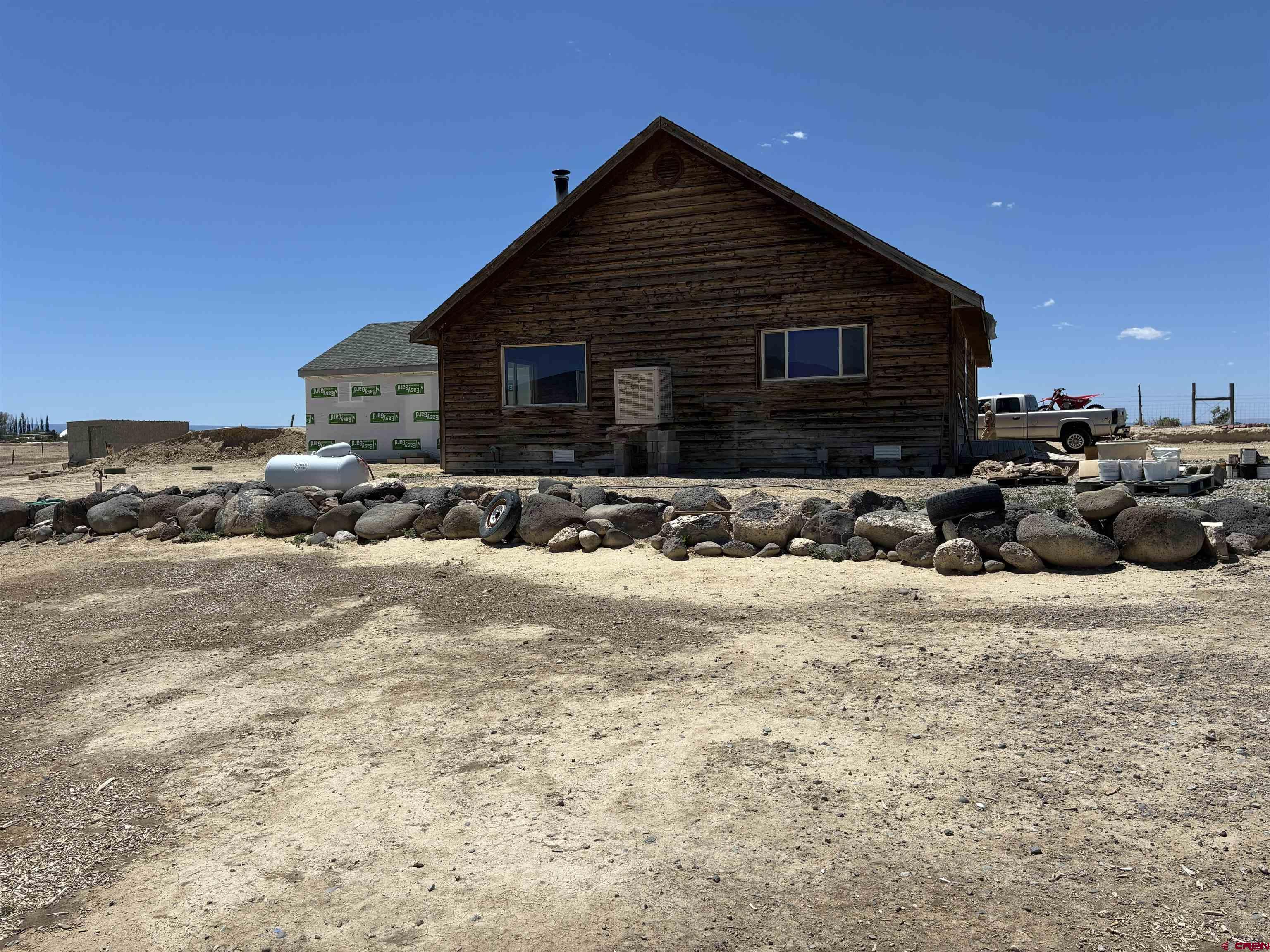 Discover this peaceful 40-acre rural retreat just a few minutes from Delta Co. Approximately 30 acres are fertile irrigated ground offering endless potential for farming, pasture, or simply enjoying the open space. The four-bedroom, two-and-a-quarter bath home features a newer addition and is currently receiving fresh updates to the roof, siding, and finishes. Additional features include a spacious 2,000-square-foot Quonset hut shop with power and room for vehicles or equipment, plus a small barn perfect for animals or storage. Centrally located with convenient access to Delta and the Montrose airport just 30 minutes away, this property offers the ideal blend of country living and practicality. If you want to hop on your side by side you can be to the Black Caynon in just a few minutes.