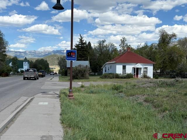 Located along Ridgway’s highly visible Sherman Street Corridor—the main route connecting Ridgway to Telluride—this historic 1909 brick property offers an exceptional opportunity for homeowners, investors, entrepreneurs, and professionals seeking a flexible live/work property in one of Southwest Colorado’s most desirable mountain communities. Rich with history and character, this rare structure is one of only a handful of original brick buildings still standing in Ridgway and combines historic charm, commercial flexibility, and future development potential in a truly unique setting.  Located within Ridgway’s Business Service Corridor zoning district, the property is ideal for a variety of residential, professional, or soft commercial uses including a single-family residence, attorney’s office, medical or wellness practice, psychologist’s office, real estate office, art gallery, design studio, counseling center, or other professional workspace.  Inside, you’ll find original fir and oak hardwood flooring, exposed interior brick accents, abundant natural light, and inviting spaces full of warmth and authenticity. The main level includes a spacious living area, kitchen, bedroom, and two bathrooms, while the enclosed rear sunroom-style space is surrounded by windows and creates a bright, inspiring environment for living, working, or meeting with clients. The basement provides valuable storage and convenient utility access.  The investment potential is especially attractive. The parcel includes three full Town lots plus a portion of the Sherman Street lot, totaling approximately 10,650 square feet and potentially allowing a split into two separate building sites. Retain and renovate the historic structure while building on the second lot, or potentially sell the additional parcel separately for added value. In a market where buildable in-town Ridgway lots are increasingly scarce, this flexibility creates outstanding long-term opportunity.  Sherman Street provides excellent visibility, easy access, and strong exposure along Ridgway’s primary corridor toward Telluride. Whether you’re seeking a historic Ridgway home, Telluride corridor investment property, professional office, redevelopment project, or live/work opportunity, this remarkable property delivers location, versatility, and character rarely found in today’s market. Historic, spirit-filled, commercially flexible, and priced to sell, this is one of Ridgway’s standout opportunities.