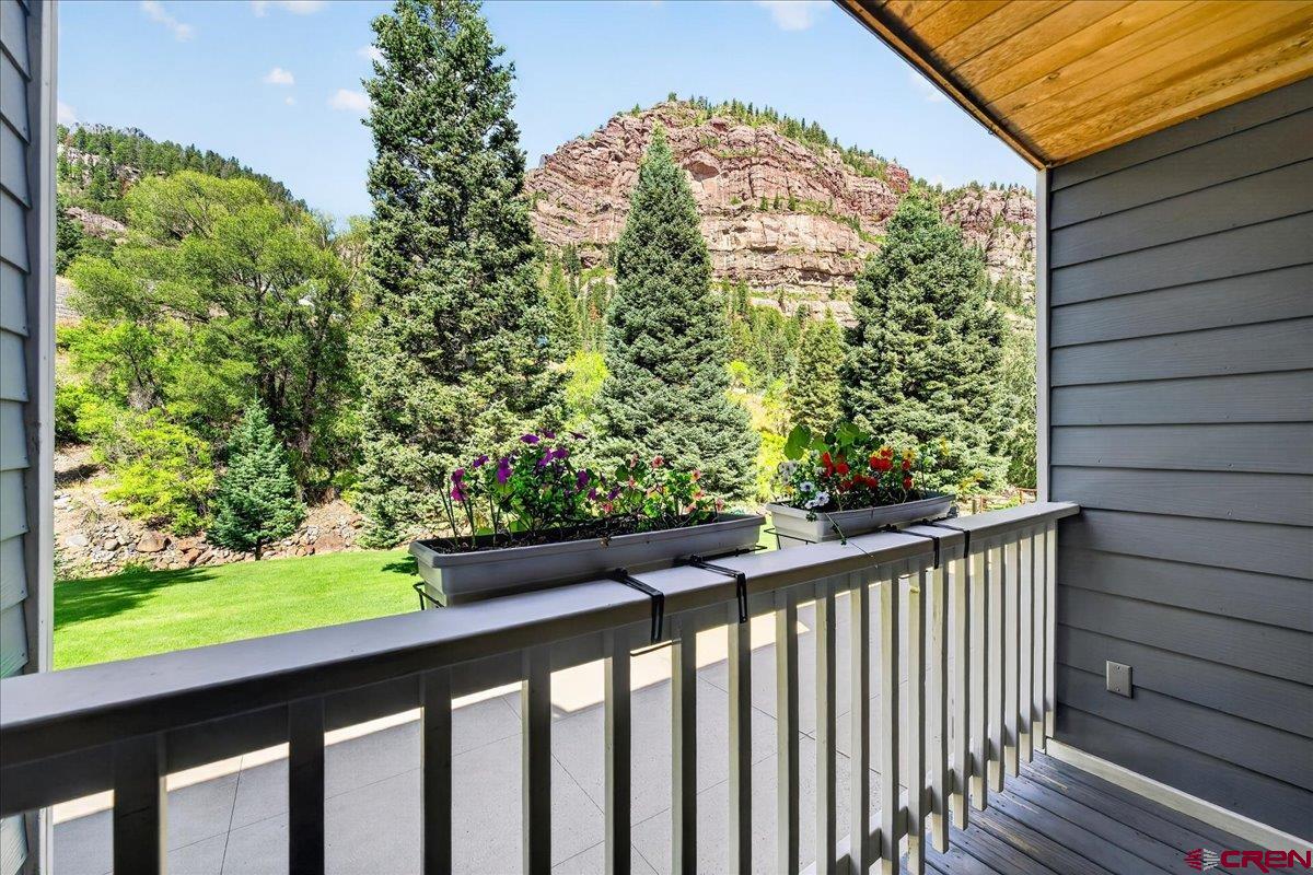 Lovely townhome with stunning mountain views and a serene setting along the Uncompahgre River. This beautifully maintained, lock-and-leave mountain retreat offers the carefree lifestyle you've been dreaming of and is within walking distance of everything Ouray has to offer. The home features two spacious ensuite bedrooms. The primary suite overlooks the river and includes a walk-in closet and a separate office that could easily serve as a nursery or third bedroom. The second ensuite bedroom enjoys views of the beautifully maintained HOA green space from its balcony. Enjoy two private balconies—one in front with sweeping mountain views and overlooking the HOA's lush green space, and one in back with peaceful views of the Uncompahgre River. The inviting front porch is the perfect place to relax in a rocking chair and take in the cool mountain air. Whether you're looking for a full-time residence, a second home, or a low-maintenance mountain getaway, this exceptional townhome offers the perfect blend of comfort, beauty, and convenience.