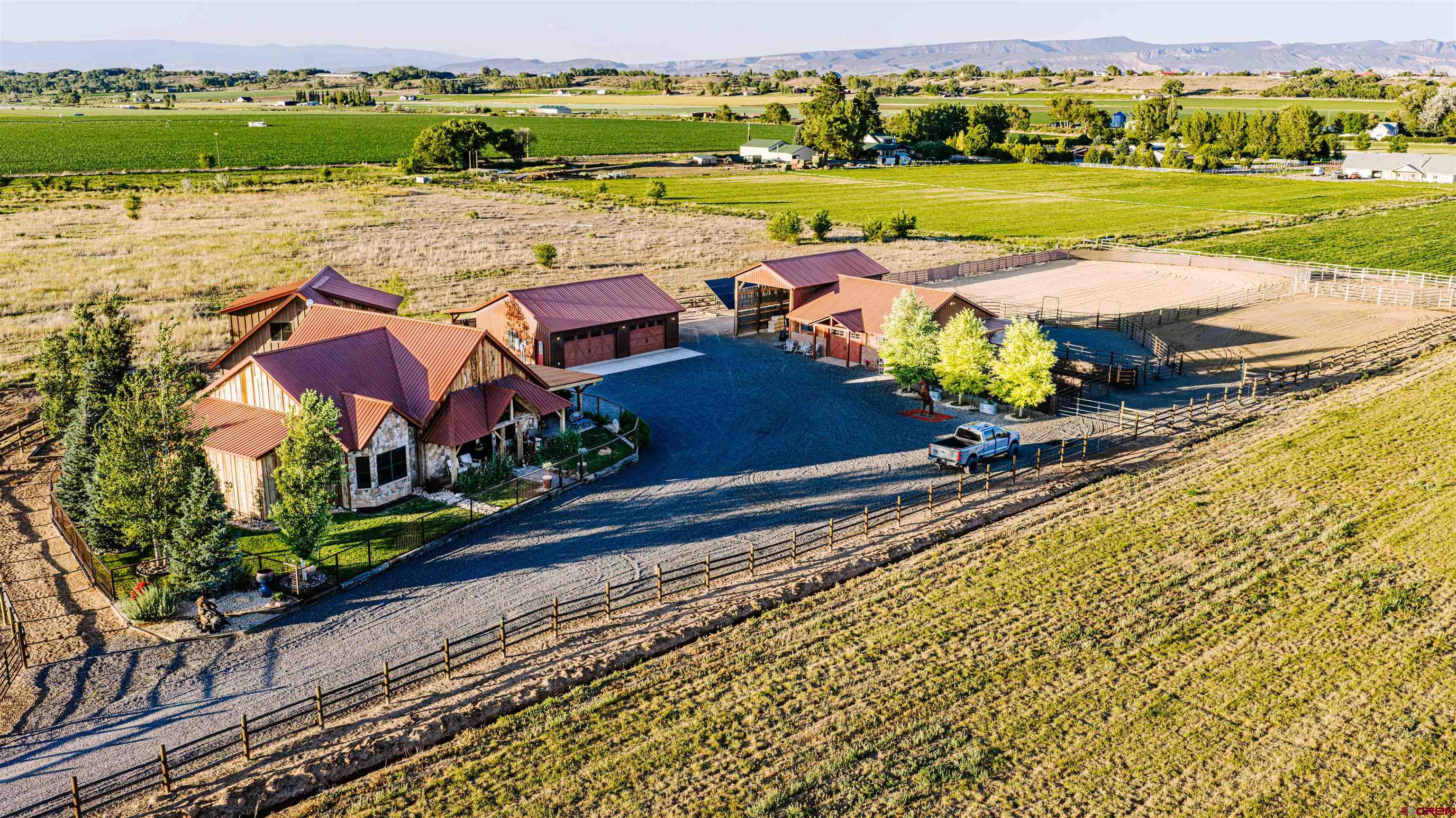Coal Creek Reserve brings together a custom timber-frame home, guest residence, equestrian improvements, and irrigated acreage on 20 acres in a part of Colorado where this combination is increasingly difficult to find. Designed for full-time living, horse use, and recreation, the property offers exceptional improvements, mountain views, and everyday functionality.  Key Features: • Custom 2,297± sq. ft. timber-frame home with three en-suite bedrooms. • Detached 645± sq. ft. guest residence with full kitchen and living area. • Four-stall Lexington-style barn with run-outs. • Heated 30' x 40' shop. • 19 UVWUA irrigation shares supporting pasture and hay production.  A custom equestrian entry gate welcomes you to a remarkable timber-frame residence showcasing reclaimed vintage wood inside and out, soaring cathedral ceilings, hand-scraped hickory floors, and exceptional craftsmanship throughout. The open-concept floor plan is ideal for entertaining and mountain living, featuring three en-suite bedrooms, including dual primary suites on the main level and a private upper-level guest suite with a Juliet balcony overlooking the great room.  The dramatic great room features exposed reclaimed beams, vaulted tongue-and-groove ceilings, expansive windows framing the San Juan Mountains, and a floor-to-ceiling stone fireplace. The gourmet kitchen offers custom hickory cabinetry, granite countertops, a farmhouse sink, walk-in pantry, and an artisan-crafted breakfast bar with stamped leather detailing.  The detached 645± sq. ft. guest residence includes a full kitchen, private bedroom, bathroom, and spacious living area with mountain views. Both homes are equipped with central HVAC and forced-air natural gas heat.  Supporting improvements are equally impressive. The heated and insulated 30' x 40' shop features built-in storage, 220V service, and a 200-amp panel. More than $400,000 in recent upgrades include a 2024 ground-mounted solar system tied to the local electric provider, a 27.5 kW Generac natural gas backup generator serving the entire property, a custom automated entry gate, welded perimeter fencing, and numerous interior and exterior improvements.  Designed for serious equestrian use, the four-stall Lexington-style barn mirrors the home's craftsmanship while remaining highly functional. Amenities include oversized stalls with run-outs, commercial rubber mats, Rocking J Dutch doors, hot-water wash bay, custom tack room cabinetry, automatic waterers, indoor hay storage, and a covered hay shed. Additional improvements include two riding arenas, a round pen, covered stalls, irrigated pasture, and direct access to nearby public land.  The property includes 19 UVWUA irrigation shares, approximately 7 acres of Timothy hay production, and 10 acres of Alfafa/Timothy Grass a 10-inch irrigated pasture pipe system, three pump-handled water taps, a permitted well, and a permitted 10-foot-deep pond holding approximately 71,700 gallons. Mature aspens, blue spruce, a new 12-zone irrigation system, and sweeping views of the San Juan Mountains, Grand Mesa, Black Canyon, and surrounding valleys complete the setting.  Coal Creek Reserve offers a rare combination of luxury craftsmanship, quality horse infrastructure, irrigated acreage, modern energy resilience, and outstanding Western Colorado scenery. Furnishings are negotiable. Seller Financing Available.