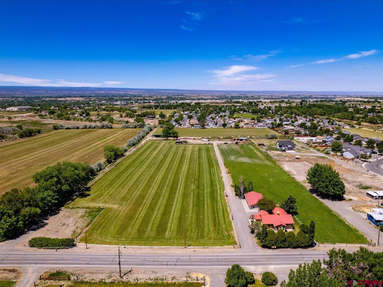 Rare Development Opportunity in a Prime Montrose Location! Unlock the potential of 13 acres of exceptional real estate located within an Opportunity Zone, offering an outstanding investment for developers, builders, and visionary investors. Currently zoned General Residential (R), this property presents exciting possibilities for future high-density residential development (subject to applicable approvals). An additional 5 acres is also available south of this parcel and listed.  Both could be purchased together. Perfectly positioned just 1.7 miles from Townsend Avenue, you'll enjoy easy access to Montrose's main commercial corridor, shopping, dining, healthcare, and everyday amenities—making this an attractive location for future homeowners. The property already offers valuable infrastructure, including a residence, a detached three-car garage, a sewer tap, and ample irrigation water shares. A paved road extends to the northwest boundary, providing convenient access and adding to the property's development potential. Whether you're looking to maintain the acreage as an irrigated property for livestock and agricultural use or capitalize on the opportunity to create a thriving residential community, this versatile property offers the flexibility to bring your vision to life. Properties of this size, location, and potential are becoming increasingly rare—don't miss your chance to invest in the future of Montrose.