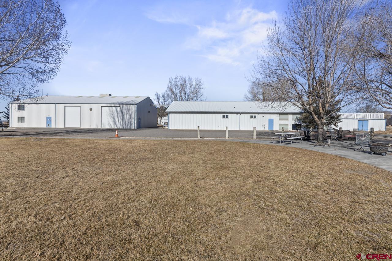 This unique 10,260 sq. ft. live-work-barndominium residence property on 2.02 acres blends comfortable residential living, privacy and multi-use workshops. The main 6186 sq. ft. residence building features open-concept living space with two large bedrooms, a modern full bathroom, and a large upstairs loft ideal for an office space, game room or home theater. New cooling system, July 2026.The living area flows seamlessly into a private, fully enclosed courtyard for indoor-outdoor enjoyment. The attached shop includes 2 -12ft. over head doors,   and 1/2 bathroom. The second 4,074 sq. ft. building has 2-14 ft. overhead doors, mezzanine for storage,  separate office/apartment. Both buildings are serviced by three- phase power and 400-amps electrical service. The expansive yard setting is designed for gatherings, relaxation, and entertainment.  This rare one-of-a-kind I-1 zoned barndominium-style workshop residence offers exceptional value and versatility.  With numerous possibilities and flexible-use potential, this unique property is ready for business, hobbies, storage, rental opportunities and more. Don't miss it, schedule a showing today.