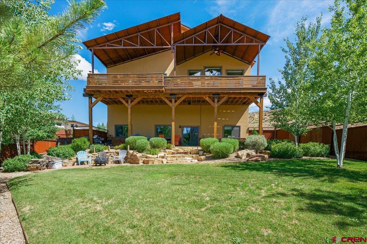 Gorgeous Custom Home with Spectacular Mountain Views!  Quality craftsmanship and attention to detail are evident throughout this exceptional custom home, where luxury finishes and breathtaking views come together to create the perfect Colorado retreat.  The heart of the home is a stunning chef's kitchen featuring granite countertops, a tiled backsplash, custom high-end cabinetry, a copper bar sink in the oversized island, a custom copper range hood, gas cooktop, double ovens—including a combination convection/microwave oven—a wine refrigerator, and a spacious walk-in pantry. Designed for both everyday living and entertaining, the open floor plan captures incredible views of the Sneffels Range and the sweeping valley below, including majestic Mount Abram.  The luxurious primary suite is conveniently located on the main level and offers an impressive walk-in closet, a spa-inspired five-piece bath with an oversized walk-in shower, and a relaxing soaking tub.  A beautiful custom railing leads to the lower level, where you'll find two additional bedrooms, an expansive family room anchored by a floor-to-ceiling stone gas fireplace, a dedicated workout area, additional cabinetry and countertop space, and an exceptionally large dry storage room.  Outdoor living is just as impressive. The oversized covered deck on the main level provides ample space for outdoor dining, relaxing, and entertaining while enjoying some of the area's most spectacular mountain views. The beautifully landscaped backyard features mature trees, a covered patio, a custom metal privacy fence, a fire pit area, and built-in speakers for both the patio and upper deck. Just off the kitchen, a separate grilling deck makes outdoor cooking convenient and enjoyable. The main level also includes a private office, perfect for working from home.  Located at the end of a private drive, this home offers exceptional privacy and a walking path that connects directly to the river trail below. Enjoy the convenience of being within walking distance of Ridgway Town Park, downtown Ridgway, local restaurants, shops, and other amenities. Additional premium features include upgraded insulation, a new water heater, water softener, furnace humidifier, electronic air cleaner, ¾-inch copper water lines, 2-inch PVC drain lines, and a heated driveway.  This remarkable home combines exceptional quality, thoughtful design, and unforgettable mountain views to offer the very best of Colorado living.