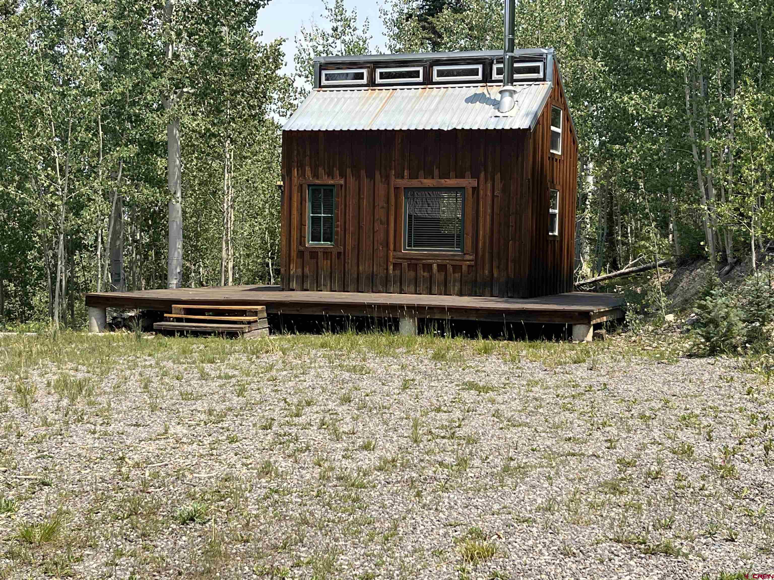 What a special spot! Tucked away in a grove of Aspen on the upper loop of San Juan Vista, this 6.6 acre parcel backs up to the National Forest and offers the perfect place to "do your own thing". If you are a hunter, direct access to the Forest is an incredibly important bonus! The cabin features a common room complete with a wood burning stove, wonderful kitchen area with a propane refrigerator and range/oven and generous counter space. Windows on every side make it light and bright. A ladder leads to the loft sleeping area with loads of light, beam ceiling, clerestory windows and plenty of room for your "stuff". The cabin is wrapped with a deck on three sides - a wonderful place to enjoy the beauty of the surrounding trees and the peace and quiet. There is also a bathhouse complete with a stall shower and portable on demand water heater. The well consistently produces 6 gallons per minute. The well pump is powered by a 10,000 watt generator. If you are looking for an off the grid experience yet want to be relatively close to Ridgway and Montrose when you need to be, this is an exceptional possibility.