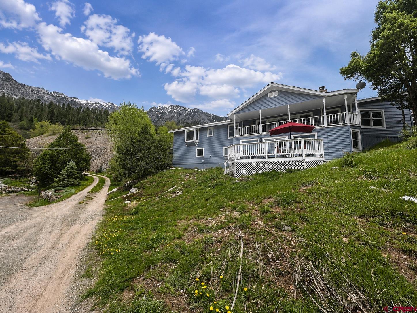 Perched above Ski Hill in the heart of Ouray, this exceptional mountain residence is an entertainer’s dream, thoughtfully designed to capture sweeping 360-degree views from an oversized, sun-filled lot. Multiple outdoor living spaces and expansive decks create the perfect setting for relaxing or hosting guests while surrounded by the dramatic San Juan peaks. From nearly every vantage point, you’ll enjoy commanding views overlooking the valley, along with iconic sights of the Amphitheater and the Twin Peaks rising above town. Inside, the home offers four spacious bedrooms and three bathrooms, providing plenty of room for family and visitors, while a private lower-level apartment adds flexibility for rental income or additional guest space. With abundant storage throughout and breathtaking mountain views framed by nearly every window, this is a truly one-of-a-kind Ouray retreat.