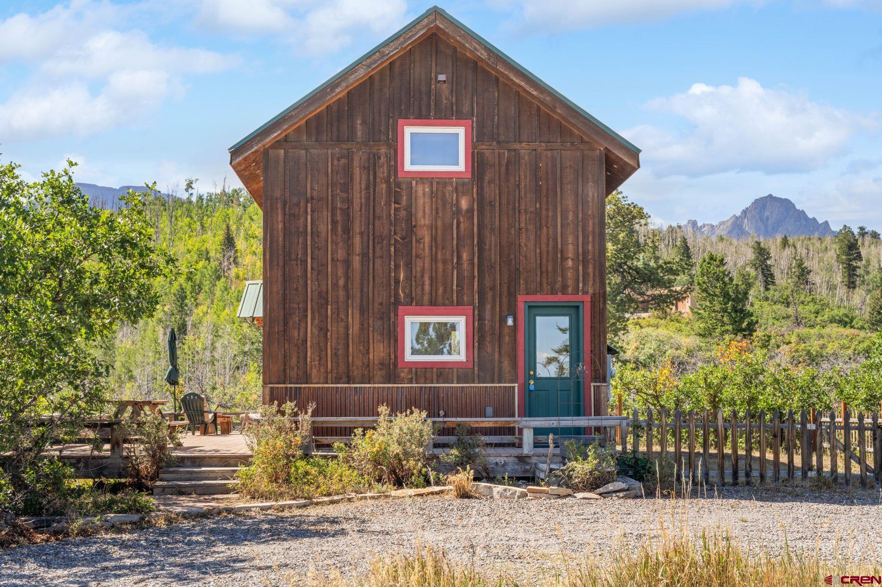 Welcome to your dream mountain retreat on 7.82 acres with views of three Fourteeners - Mount Sneffels, Uncompahgre Peak, and Wetterhorn Peak. Conveniently located at the entrance to Elk Meadows Estates, accessible year-around, this charming cabin offers a smart floor plan with kitchen and living space downstairs and a large open bedroom suite upstairs. The wrap-around deck extends your living space and draws the mountains right in. A bonus casita, perfect for a home office, guest space, or storage adds flexibility. Additional features include hot water baseboard heat, wood-burning stove, beautiful wood floors, built-in storage, metal roof, and a private setting with views, views, views. Spend your mornings and evenings on the deck watching the sun and the moon light up the mountains. Elk Meadows Estates is a high-country subdivision 15 minutes from all the amenities in Ridgway and just minutes from BLM, National Forest, steps away from Miller Mesa Trail and Top of the Pines. This is one special property worth a look.