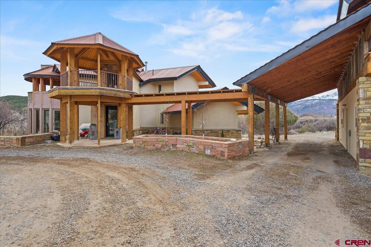 If you’ve been searching for the perfect mountain view home in Southwest Colorado, this exceptional property on nearly 10 acres on the north edge of Ridgway in beautiful Ouray County deserves your attention. Ideally located between Telluride, Ouray, and Montrose, this architect-designed contemporary residence offers the rare combination of big Sneffels and Cimarron Mountain views, privacy, easy access, acreage, and rental flexibility (subject to subdivision guidelines). Perched above the valley with the Uncompahgre River below, the home feels as if it floats above the landscape, surrounded by open sky, wildlife, and uninterrupted scenery. The main residence is thoughtfully designed across three levels to capture light and views from nearly every room. The main level opens through a practical airlock mudroom into a stunning, light-filled great room with a full wall of glass facing south toward the Ridgway-Ouray Valley. The gourmet kitchen features granite countertops, abundant cabinetry, and stainless appliances, while the unique kiva-style dining room with curved glass walls faces east to welcome the morning sun. The living room is warm and inviting with sliding wall that almost completely eliminates any glass or doors to block the incredible views.  One of the primary suites is conveniently located on this level with private deck access, a spacious walk-in closet with its own laundry, and a spa-inspired bath featuring a glass-enclosed shower and jetted soaking tub positioned to immerse you in the surrounding mountain views. Upstairs, an additional primary suite acts as a private escape, with bright central gathering area leading to private sleeping quarters on one end that has another view-oriented glass shower.  Intelligently located wings lead to a generous closet space, and access to a covered cupola offering breathtaking 360-degree panoramic views. Additionally, this level has a covered east facing covered deck that’s perfect for a future hot tub or relaxation area as well as a convenient half bath.  The walk-out lower level provides flexible space for a family room, fitness area, studio, or future expansion, along with a third regally sized bedroom and additional unfinished areas ready to customize to your needs. One of the most desirable features of this property is the detached oversized garage and auxiliary dwelling unit (ADU), carefully positioned to preserve the home’s sightlines and mountain views. The lower level garage is designed to accommodate a host of vehicles with multiple access doors and ample storage for outdoor gear and recreational vehicles. Above, the ADU offers a fully independent living space with its own entrance, kitchen, full bath, living area, and separate bedroom. This auxiliary residence is ideal for guests, multi-generational living, a caretaker, or potential long-term rental income, subject to subdivision guidelines—making this a rare opportunity for buyers seeking both lifestyle and investment potential in the Ridgway and Telluride corridor. The nearly 10-acre parcel extends toward the Uncompahgre River, offering privacy, space to explore, and room to enjoy the natural beauty that defines Southwest Colorado. Wildlife sightings of deer, elk, bald eagles, and hawks are part of everyday life here. With convenient access to skiing in Telluride, hiking and hot springs in Ouray, services and the regional airport in Montrose, and the charm of downtown Ridgway just minutes away, this property captures everything buyers are searching for in a Colorado mountain home with views, acreage, and an ADU. This is a rare opportunity to own a private mountain sanctuary in the heart of one of Colorado’s most sought-after regions.